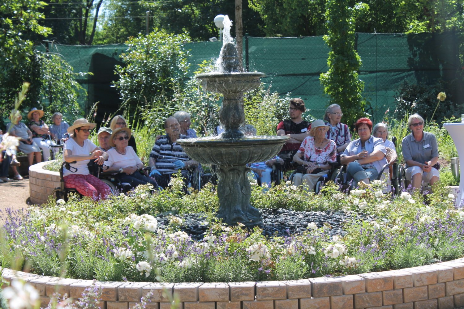 Die Gäste der Gartenparty genießen den neuen Therapiebereich im Grünen.
