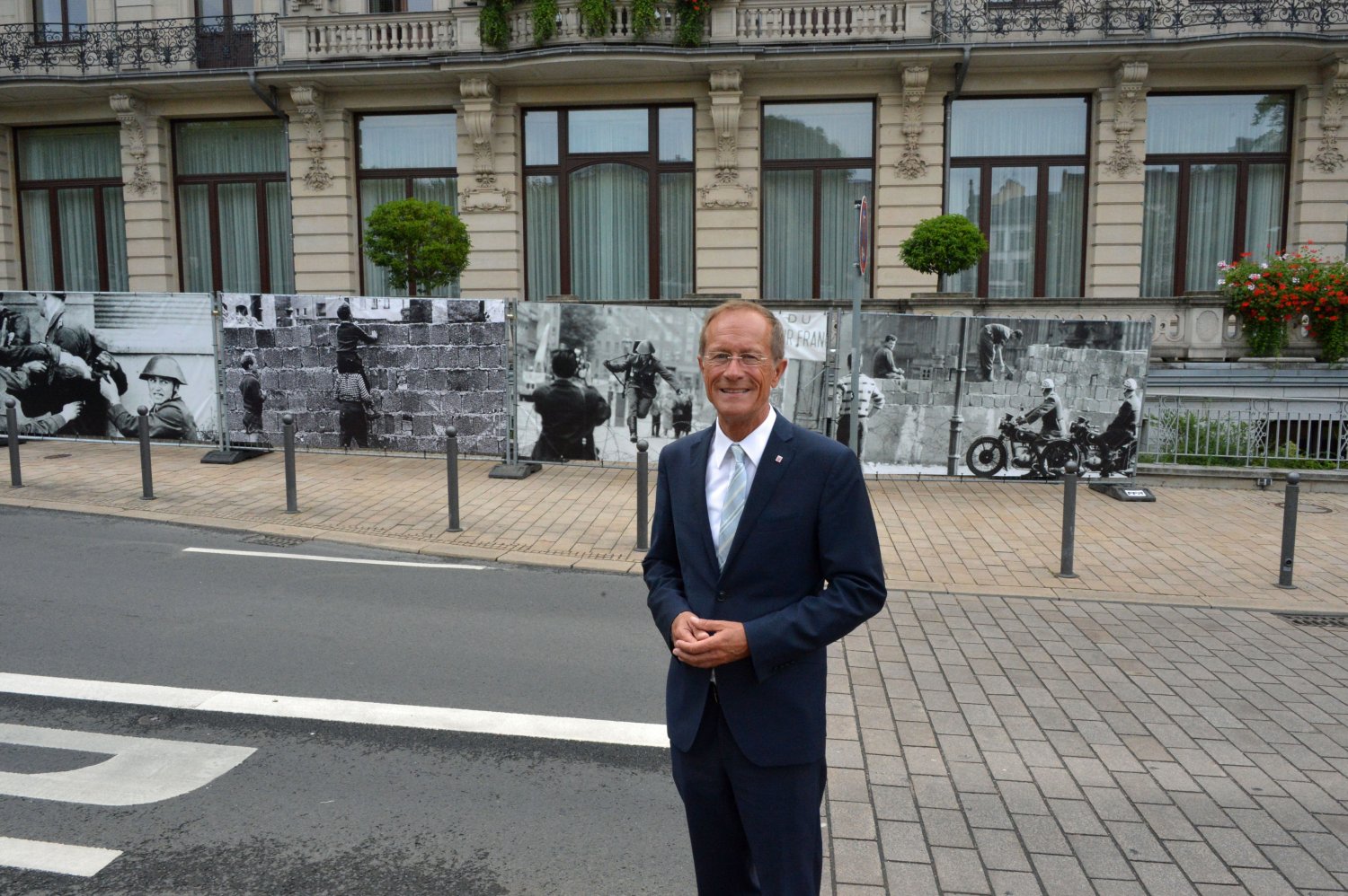Staatsminister Axel Wintermeyer vor der Fotowand, die an der Hessischen Staatskanzlei an den Fall der Berliner Mauer vor 30 Jahren erinnert.