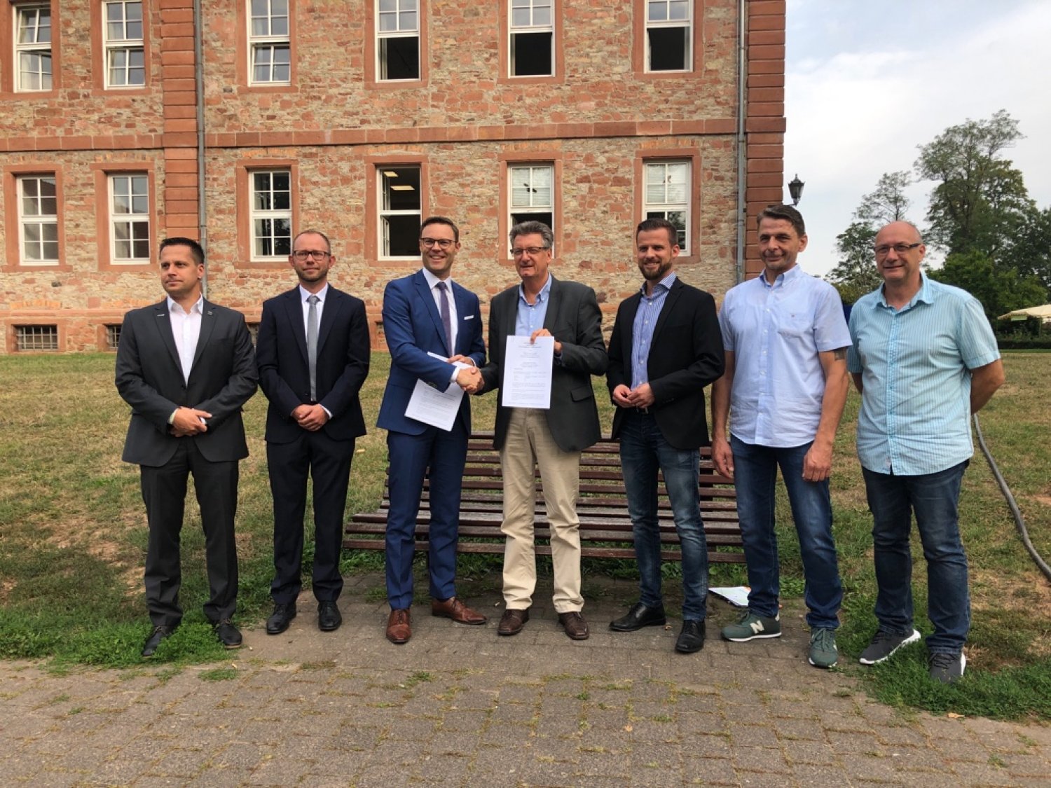 Bürgermeister Jürg Muth (4. von rechts) und Oliver Habekost, Geschäftsführer der Versorgungsservice Main-Kinzig GmbH (3. von links), nach Unterzeichnung des Vertrags.