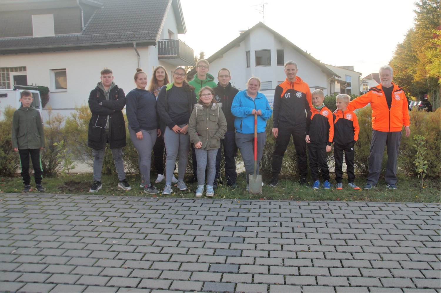Jugendfeuerwehr und Jugendfußballer zwischen den angepflanzten Bäumchen. In der Mitte mit Spaten: Initiatorin Monika Loeb.
