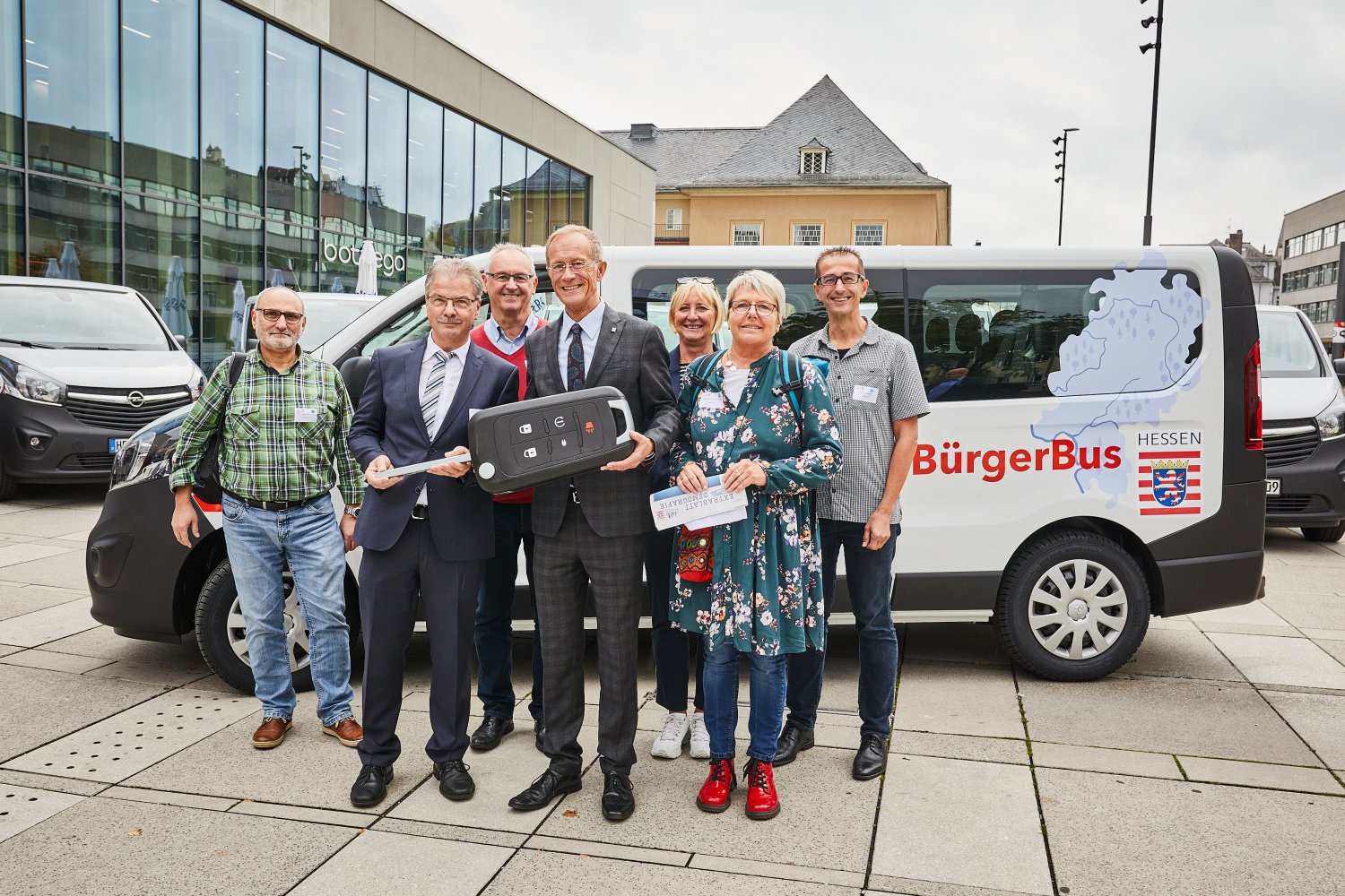 Der Chef der Hessischen Staatskanzlei, Staatsminister Axel Wintermeyer, mit den Vertreterinnen und Vertretern der Gemeinden Birstein und Schöneck aus dem Main-Kinzig-Kreis bei der Übergabe der Bürgerbusse.