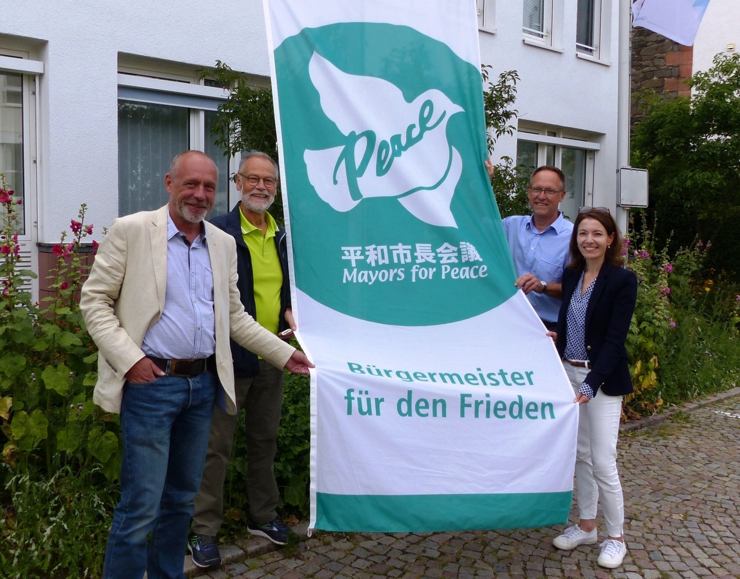 Am 8. Juli hisste Bürgermeisterin Monika Böttcher (rechts) gemeinsam mit Vertretern aus Stadtverordnetenversammlung und Magistrat die „Mayors for Peace“ Flagge vor dem Rathaus Maintal.
