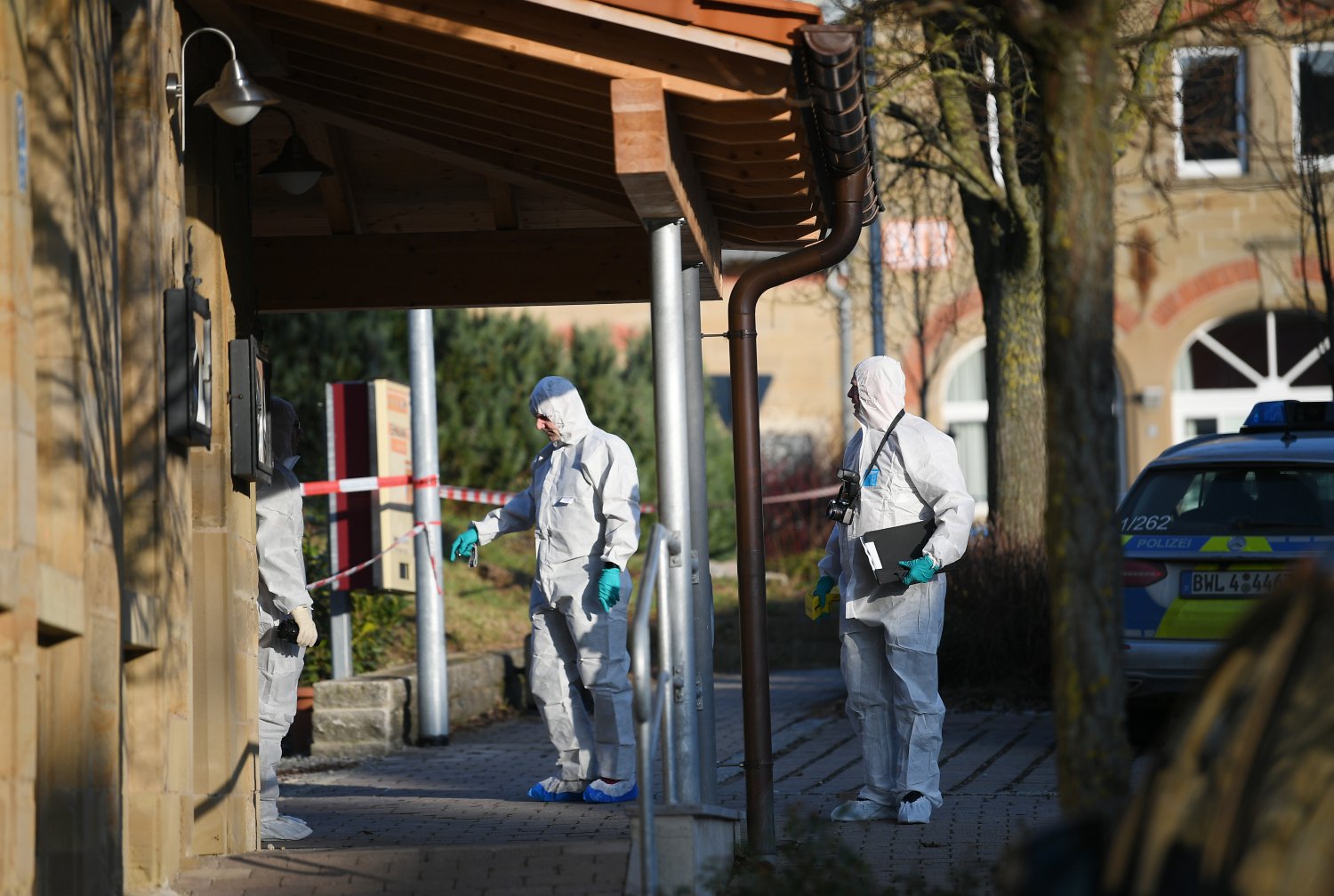Nach Schüssen in Rot am See im Nordosten Baden-Württembergs stehen Mitarbeiter der Spurensicherung der Polizei an einem Haus. Hier sollen mehrere Menschen getötet worden sein. Ein Tatverdächtiger sei festgenommen worden, sagte die Polizei.