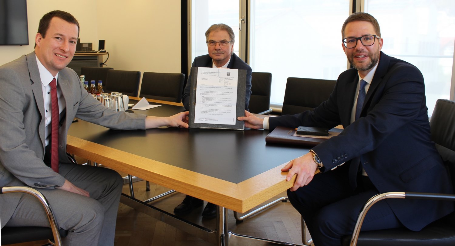 Landrat Thorsten Stolz (rechts) überreicht dem Birsteiner Bürgermeister Wolfgang Gottlieb und seinem Nachfolger Fabian Fehl den von der Kommunalaufsicht genehmigten Doppelhaushalt der Gemeinde.