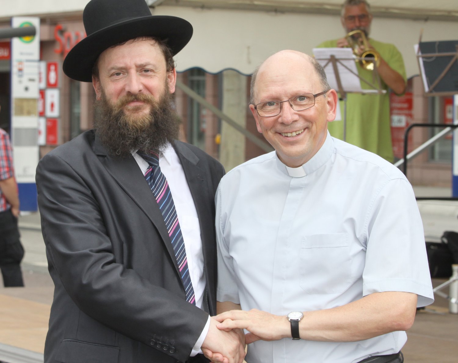 Das Archivfoto im Anhang zeigt Rabbiner Shimon Großberg mit Dechant Andreas Weber beim Fest der Religionen auf dem Hanauer Marktplatz im August 2019, welches die freundschaftliche und tiefe Begegnung zeigt