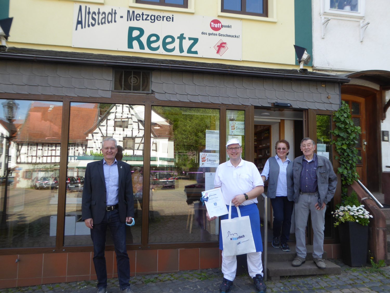 Bürgermeister Andreas Weiher, Metzgermeister Olaf Reetz mit Mutter Romana und Vater Helmut Reetz vor der Altstadt-Metzgerei Reetz am Marktplatz 