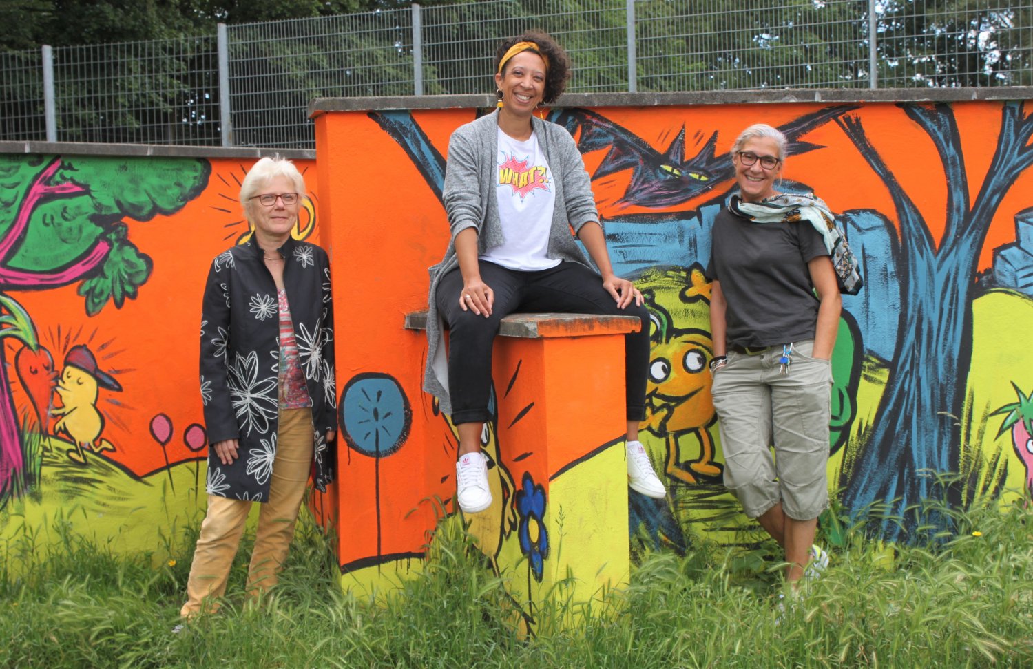 Bunt ist die Welt von heute - Sie tragen dazu bei, dass es auf dem Römerspielplatz Abwechslung und Ansprechpartner gibt: Alexandra Ihrig, Nicole Deeg und Anita Losch vor der von Jugendlichen gestalteten Graffitiwand.