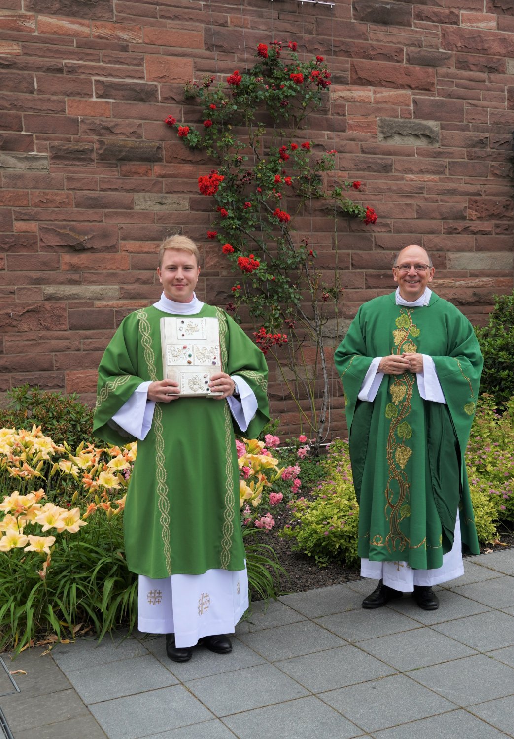 Diakon Philipp Schöppner (links) mit Evangelienbuch und Dechant Andreas Weber (rechts) beim Einzug in die St. Elisabethkirche
