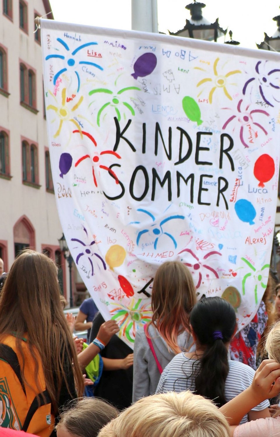 Die Kindersommer-Fahne wird 2020 coronabedingt im kleineren Kreis vor dem Rathaus gehisst.