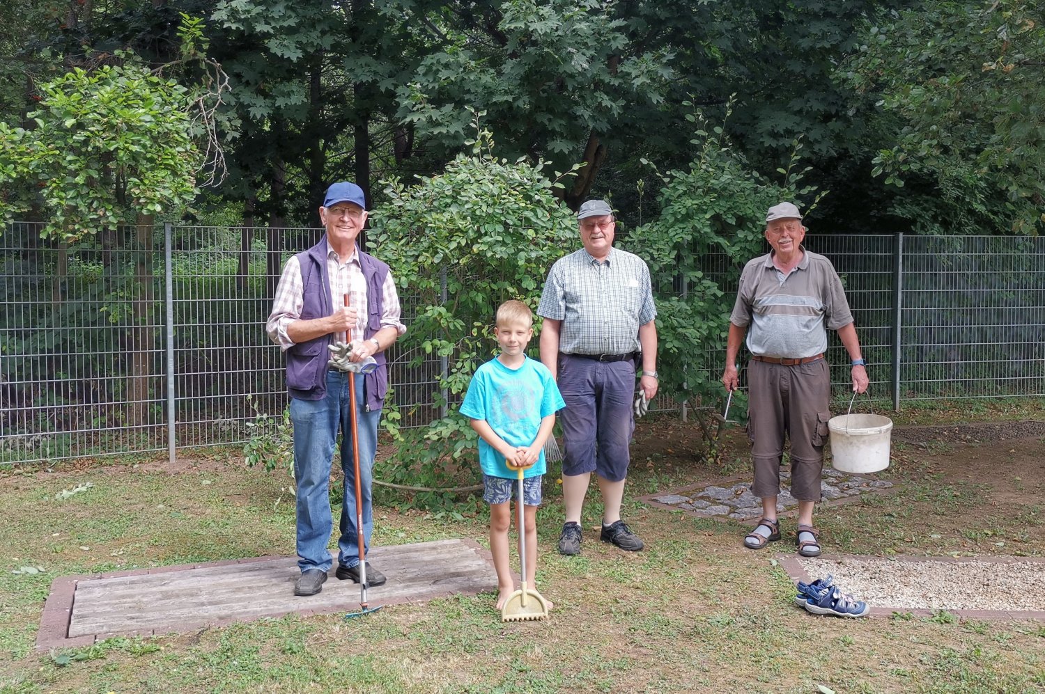 Friedel Maul, Luca, Dr. Günter Buckow und Werner Hercher pflegen den Barfußpfad.