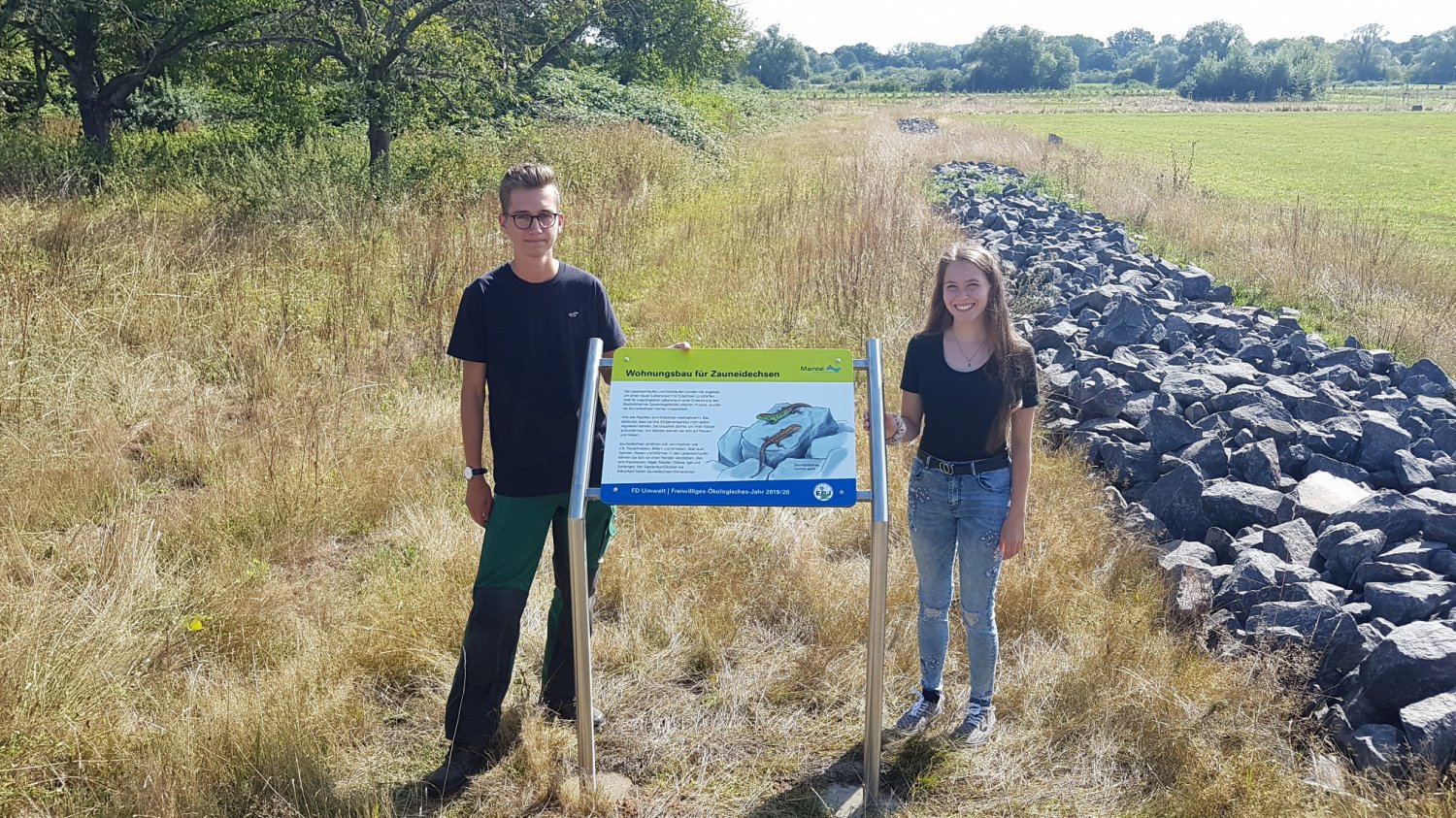 Karsten Reichelt und Layla Wahl, die „ehemaligen“ FÖJ-Kräfte, neben der Informationstafel des neuen Habitats der Zauneidechsen