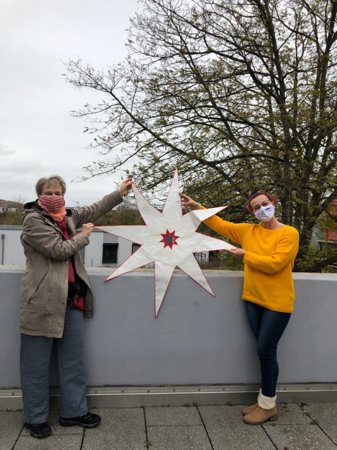 Christel Seemann übergibt die gebastelten großen Sterne an Vanessa Buono, Leiterin der sozialen Betreuung im Altenzentrum Rodenbach.