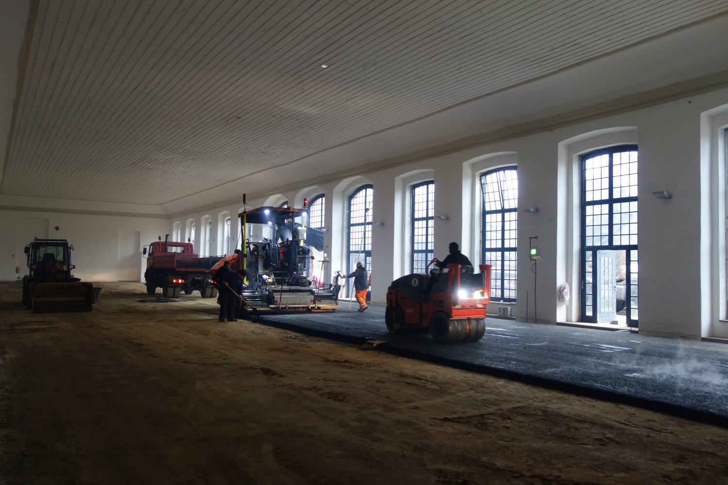 Ein strapazierfähiger Asphaltboden wird in der Orangerie eingebaut.