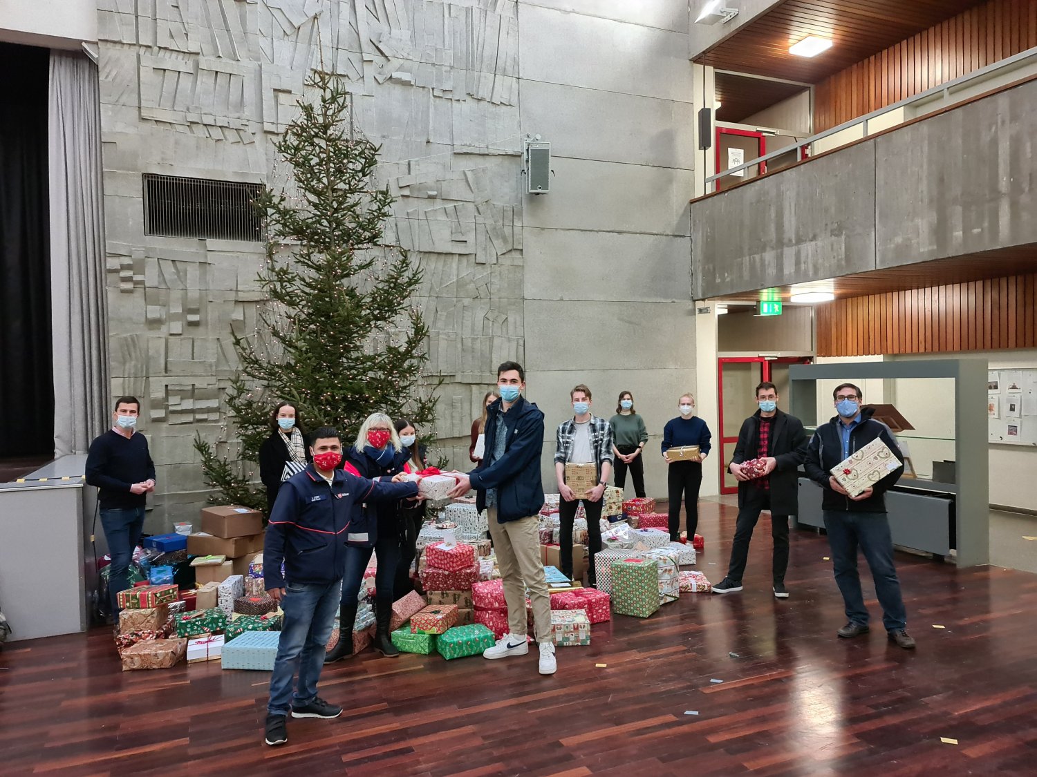 Weihnachtspäckchen-Übergabe an der Rabanus-Maurus-Schule: In der Mitte Ismail Asimi und Gabriele Mötzung (beides Malteser) sowie Schulsprecher Till Flamme-Brüne.