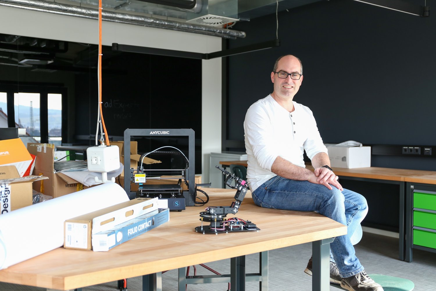 Christian Romeis sitzt im Makerspace makeIT. Nur noch die Geräte müssen ausgepackt und aufgebaut werden, dann kann in der Hightech-Werkstatt gearbeitet werden.