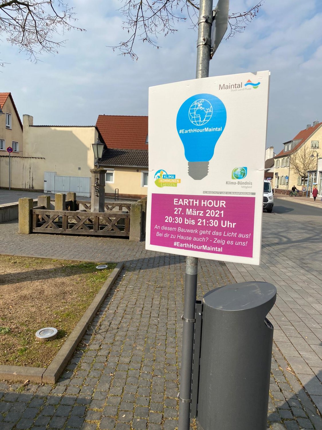 Plakate am Obertor in Hochstadt und am Brunnen am Marktplatz in Bischofsheim informieren über die geplante Abschaltung der Beleuchtung im Rahmen der Earth Hour am 27. März um 20:30 Uhr.