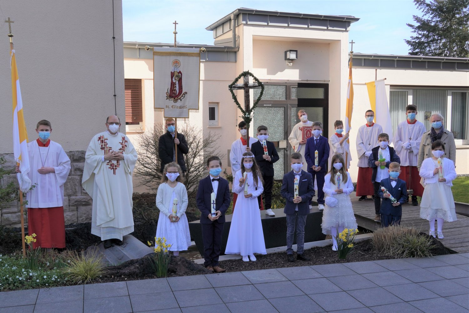 Die Kinder der Kesselstädter St. Elisabeth-Pfarrei am Tag ihrer Erstkommunion in zwei verschiedenen Feiern auf der Schiffsskulptur am Bachlauf des Kesselstädter Kirchplatzes