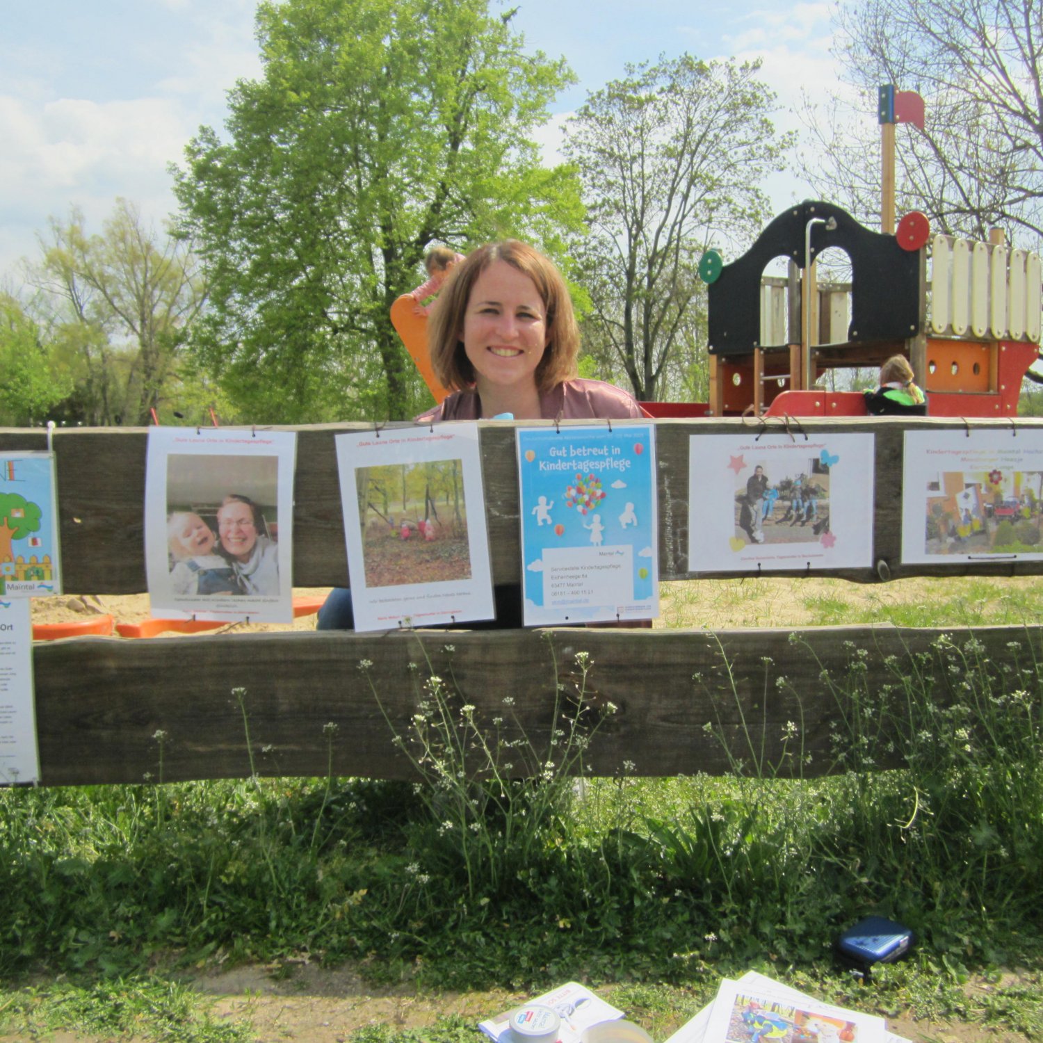 Julia Deicken von der Servicestelle Kindertagespflege Maintal (SKM) bringt auf den Spielplätzen die von den Tagesmüttern gestalteten Seiten an, die die Kindertagespflegefamilien als Gute-Laune-Orte vorstellen.