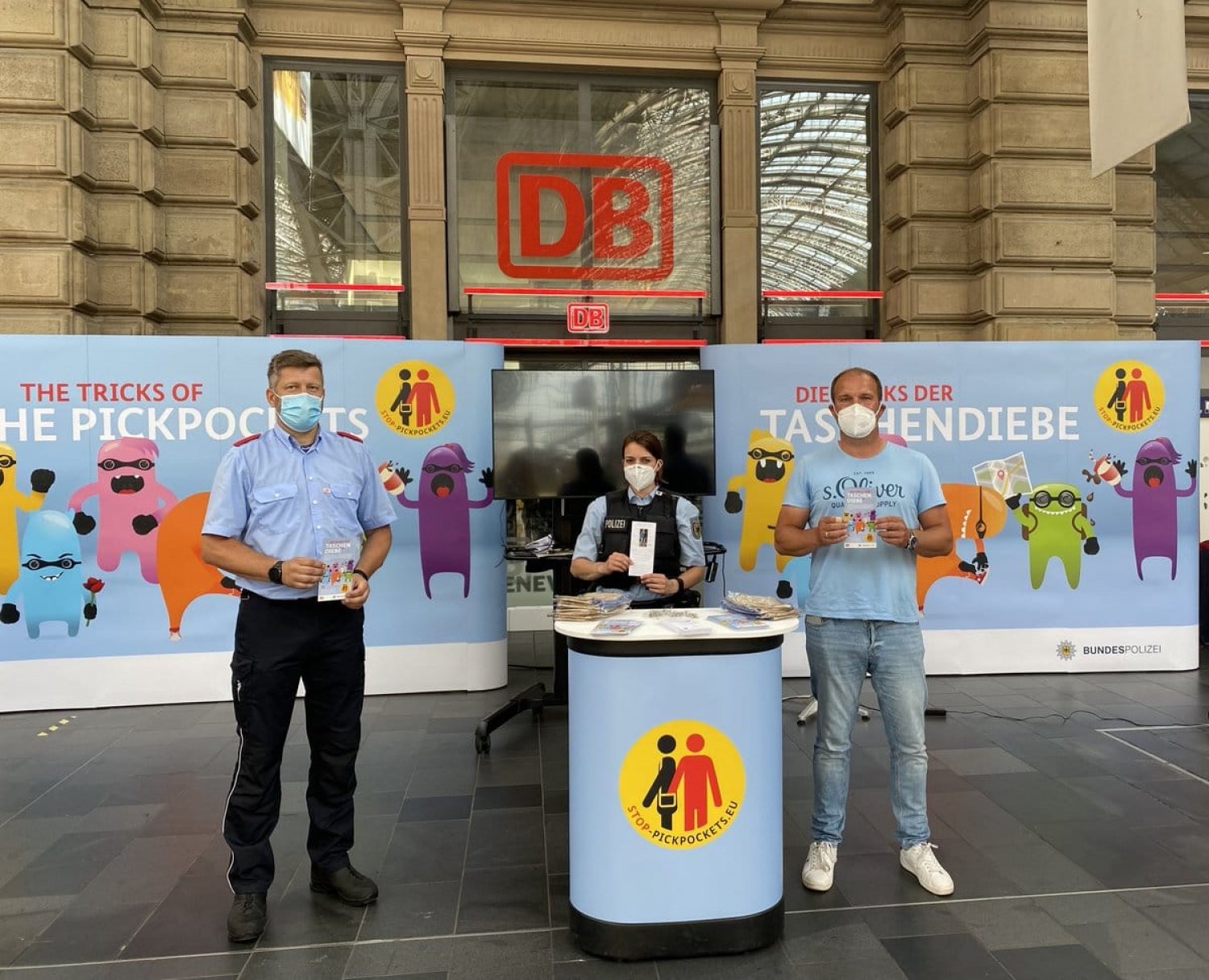 Beamte der Bundespolizei und Teams der Deutschen Bahn AG informieren Reisendes an Infoständen im Bahnhofsbereich.