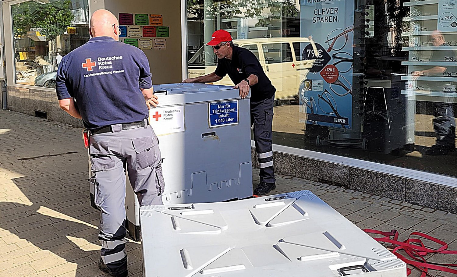 Rotkreuzbeauftragter Kai Hirchenhein mit einem DRK-Kameraden beim Aufbau der Trinkwasserversorgungstanks in Kreis Ahrweiler.