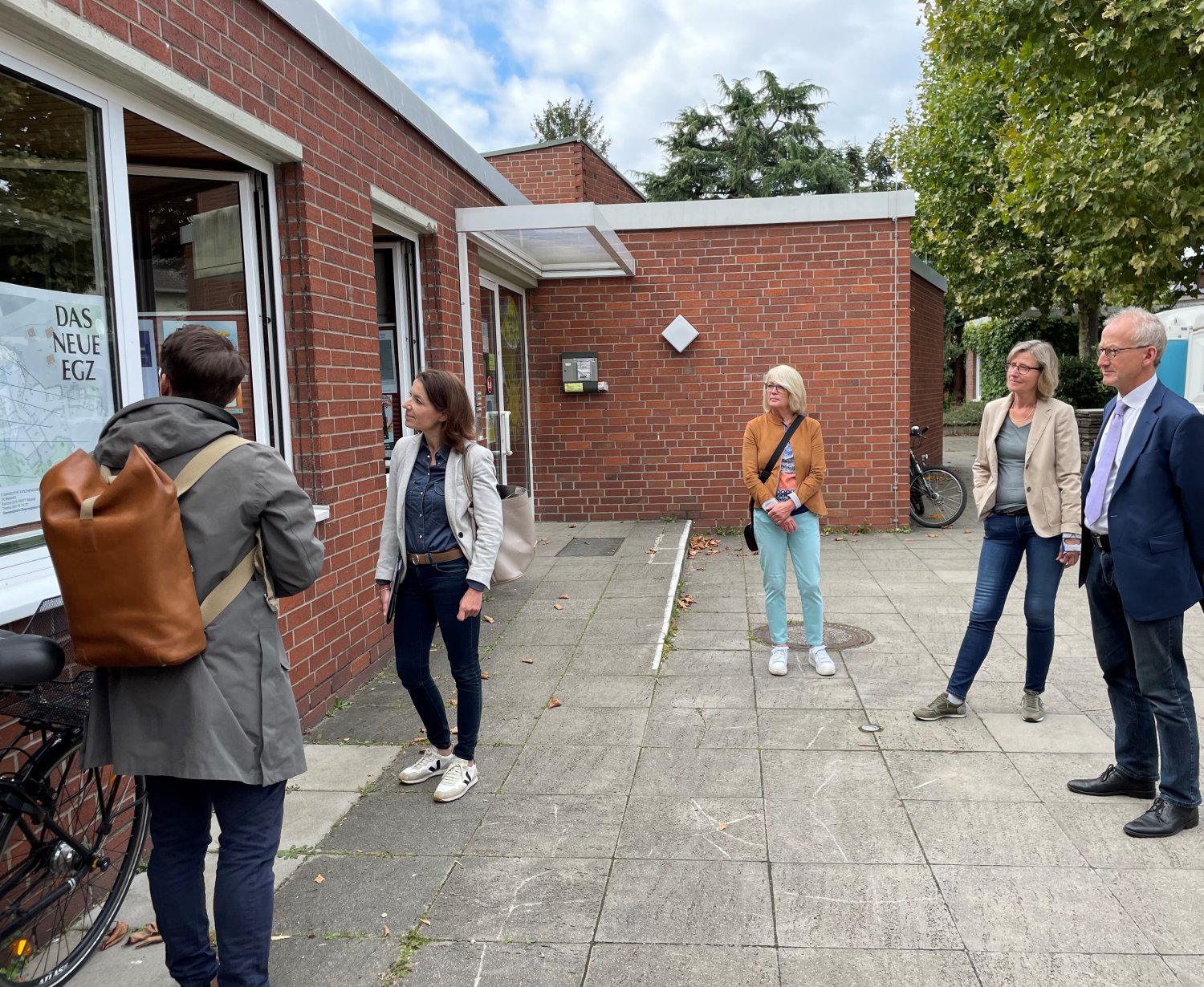 Architekt Marcel Paffrath (links) stellt den Fortschritt der Bauarbeiten am Evangelischen Gemeindezentrum vor. Interessiert verfolgen Bürgermeisterin Monika Böttcher (Zweite von links) und Pfarrer Dr. Martin Streck (rechts) die Ausführungen