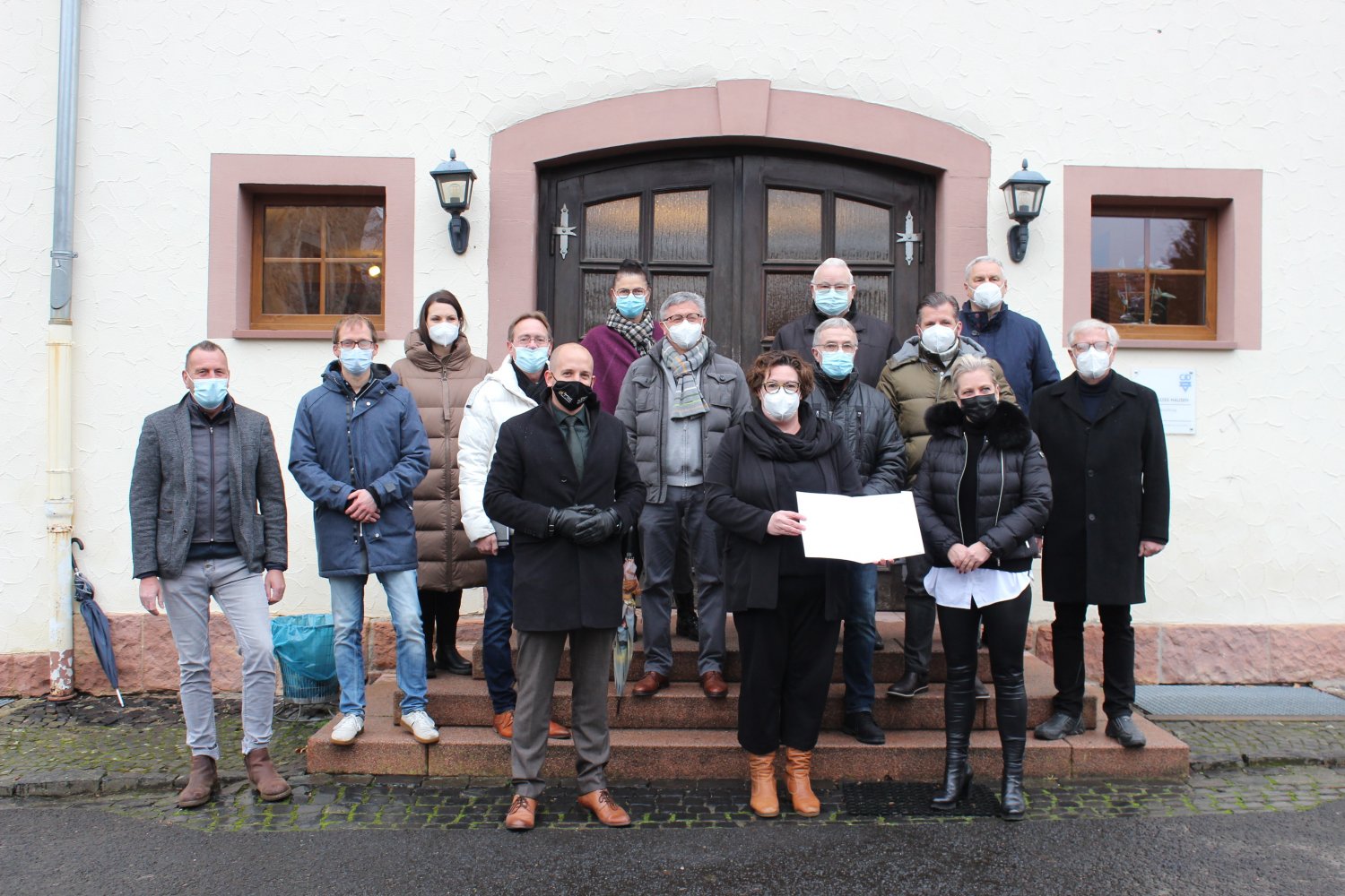Erste Kreisbeigeordnete Susanne Simmler (vorne Mitte) überbrachte einen Förderbescheid aus Mitteln der Dorferneuerung an Nicole Rademacher vom CJD, Verbund Hessen (vorne rechts), im Beisein von Bürgermeister Dominik Brasch (vorne links)