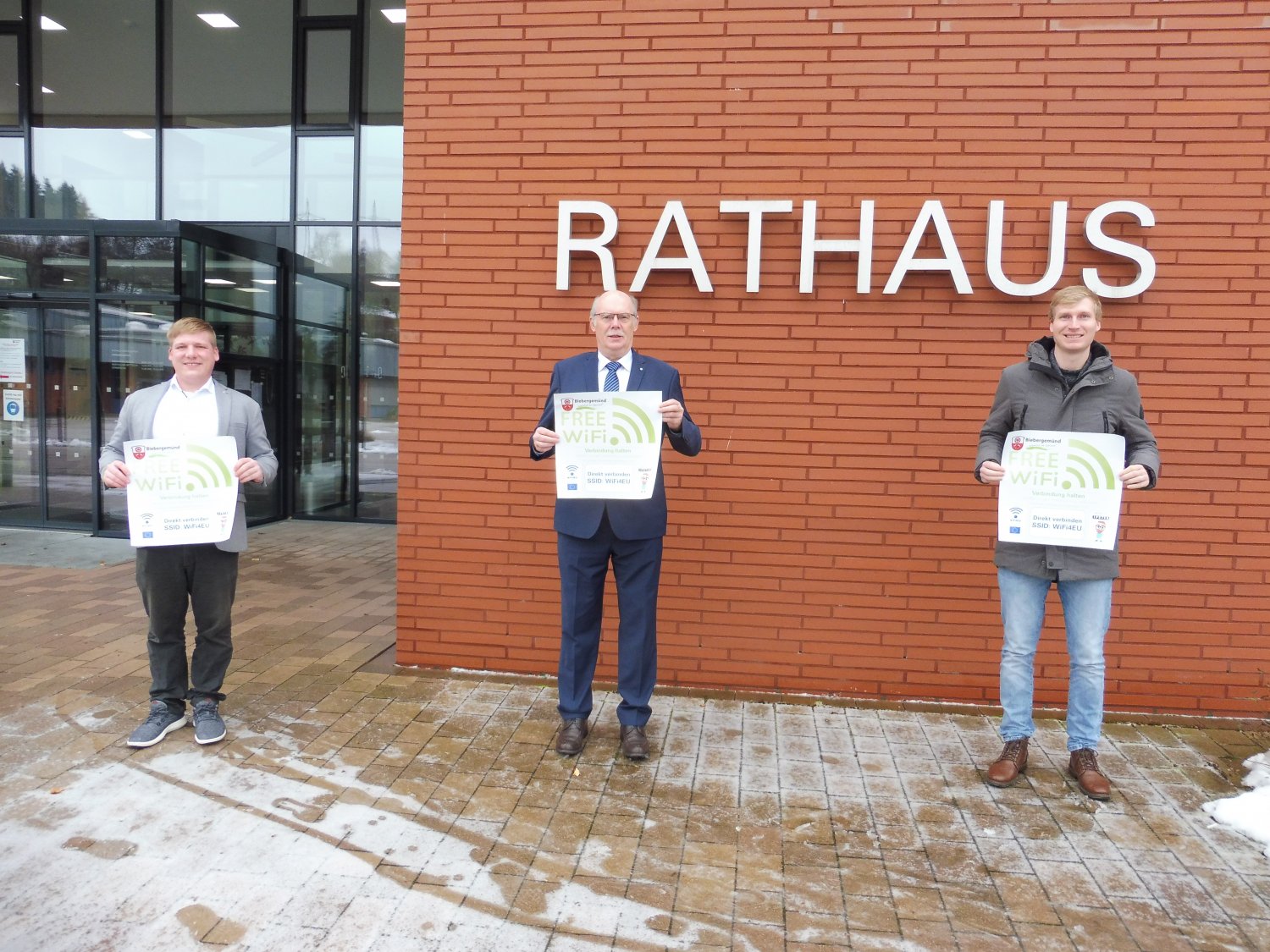 Geschäftsführer IPSTER Tim Schätzke, Bürgermeister Manfred Weber und Projektleiter Christian Baumgart (von links) präsentieren das neue Hinweis-Plakat zur WLAN-Nutzung für die 11 gemeindeeigenen Standorte.