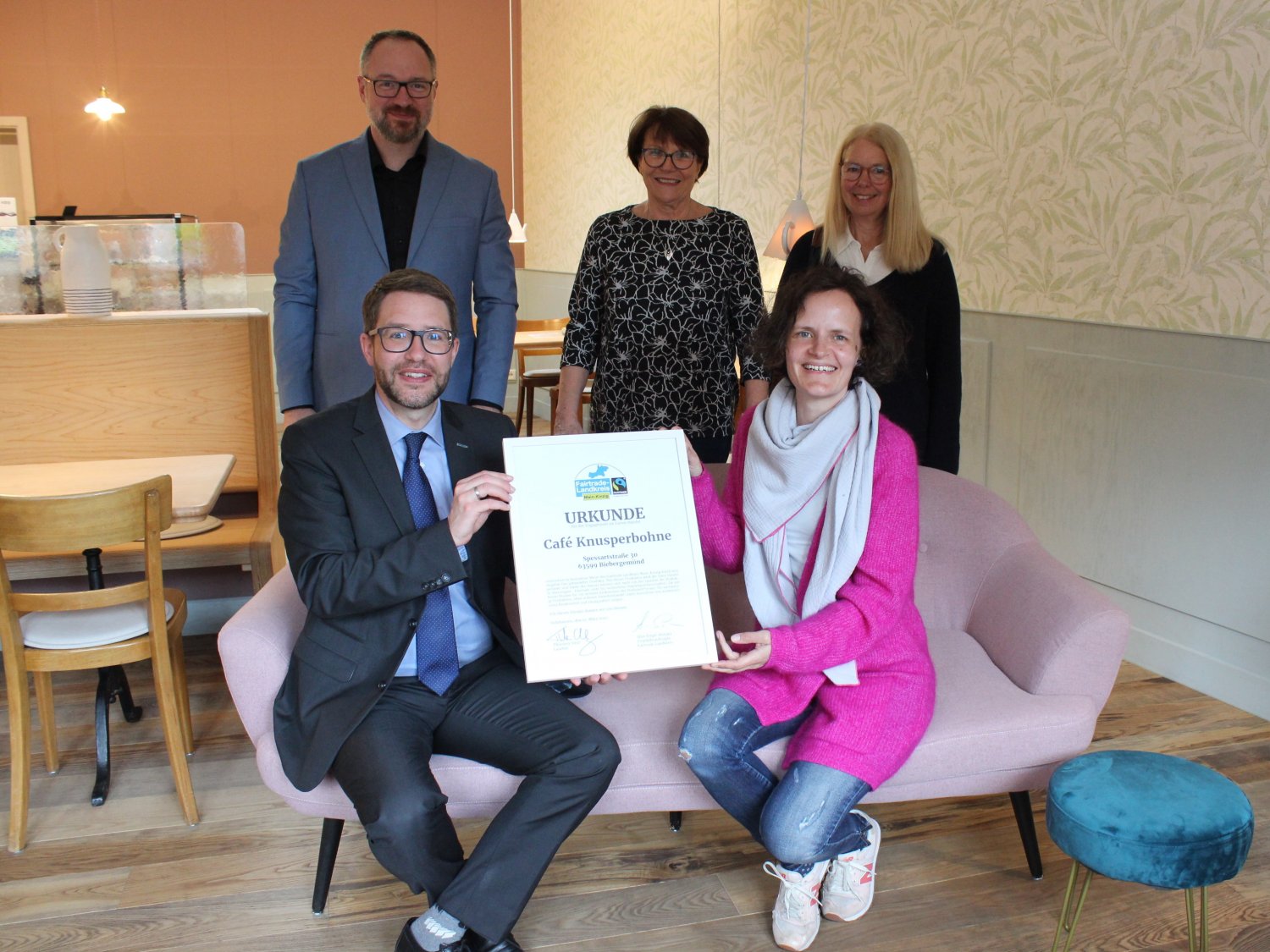 Im Café Knusperbohne überreichte Landrat Thorsten Stolz (sitzend) eine Fairtrade-Urkunde an Café-Betreiberin Beate Buch.