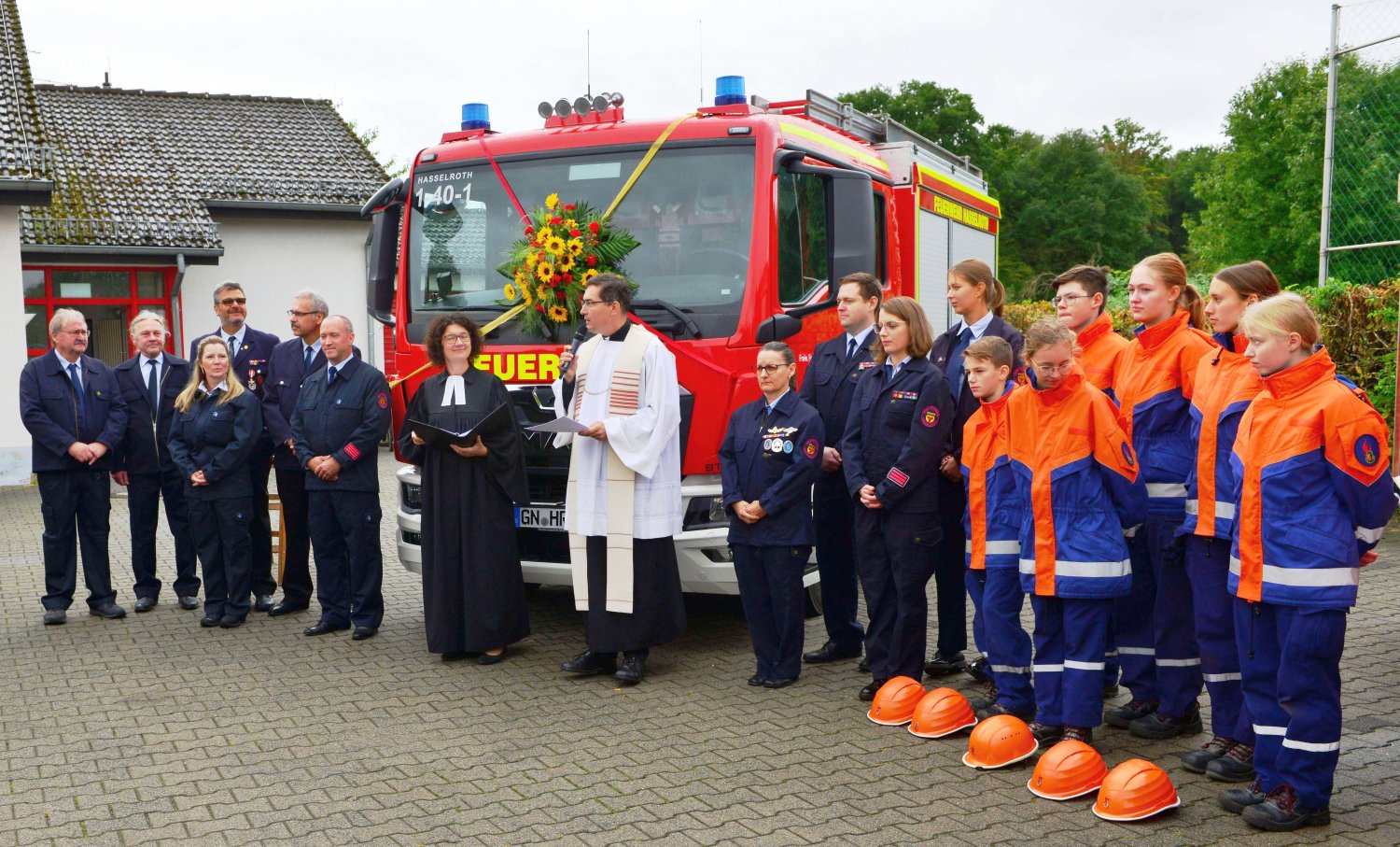 Ein Teil der Aktiven mit Jugendfeuerwehr und Pfarrerin Reinold und Pfarrer Rödig vor dem MLF.