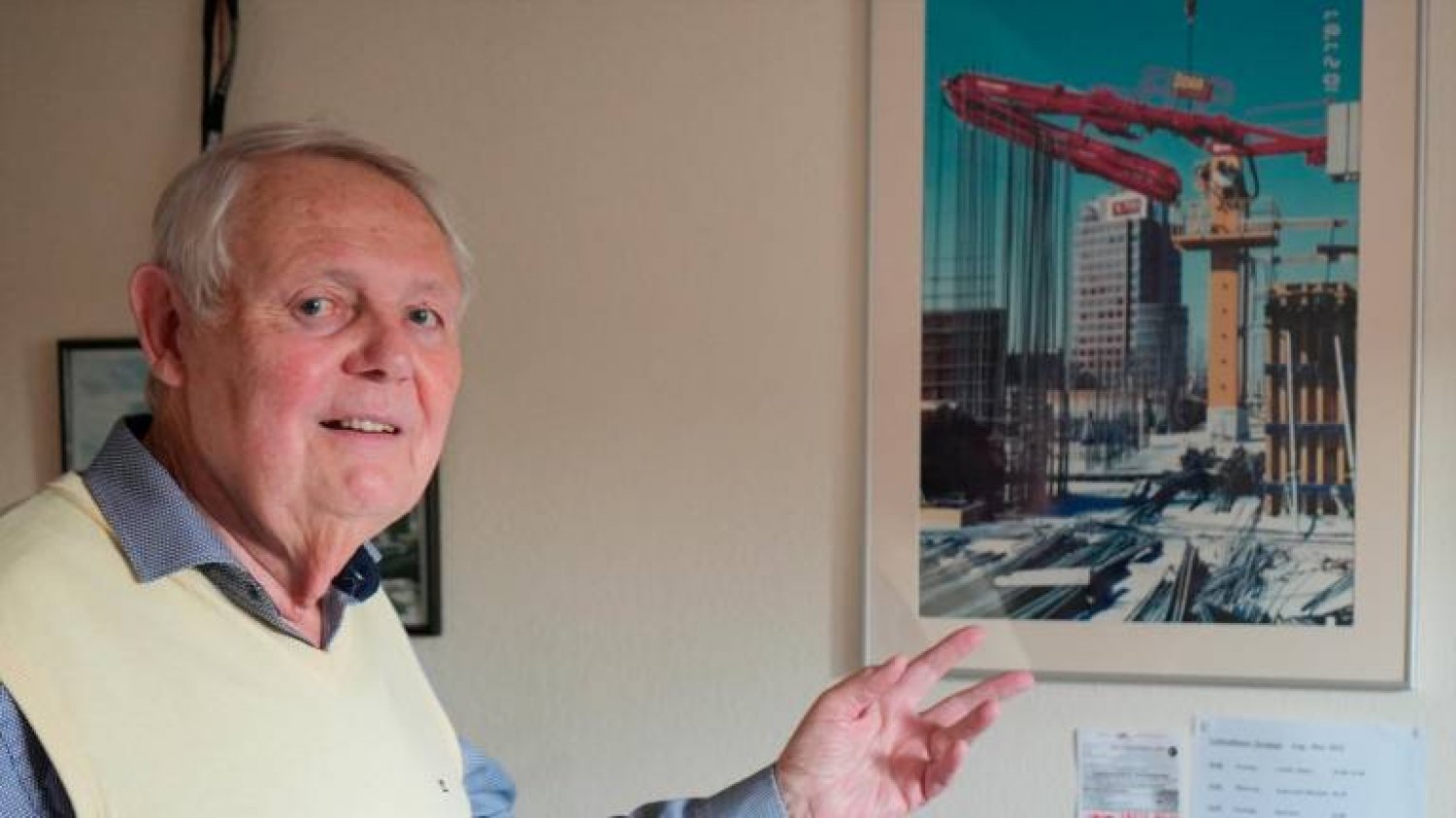 Horst Bender aus Besenkassel vor dem Bild der von ihm ersonnenen Beton-Verteilanlage, die mit dem Gebäude emporwächst.