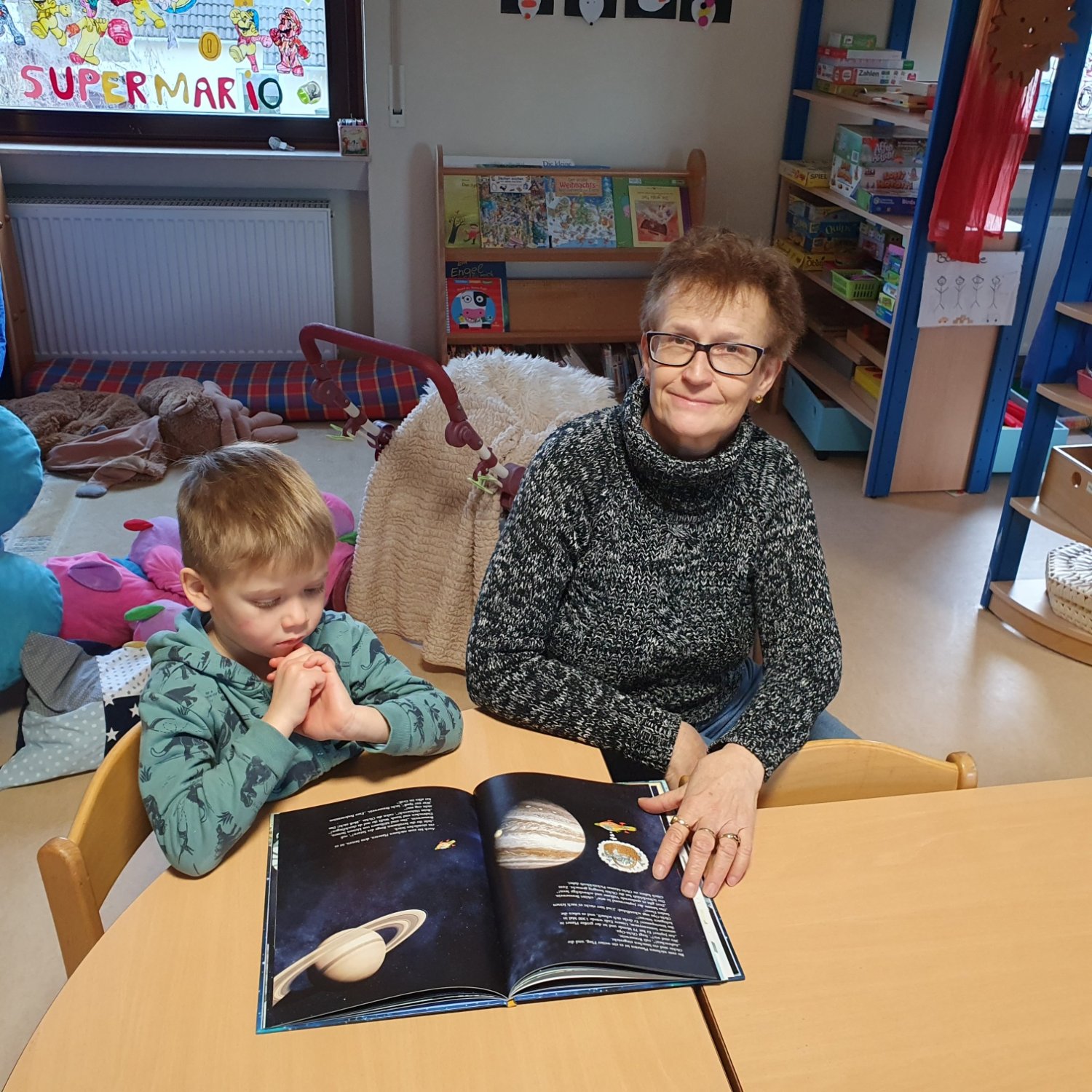 Judith Köller und Till betrachten ein Buch.