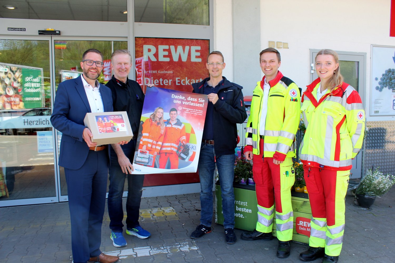 Landrat Thorsten Stolz (links) und Dr. Manuel Wilhelm (Mitte) bedanken sich bei Dieter Eckart für die Teilnahme an der Kampagne „Rettungsgasse an der Kasse“, im Beisein von Notfallsanitäterin Kristina Seifert und Rettungssanitäter Justus Wiegand 
