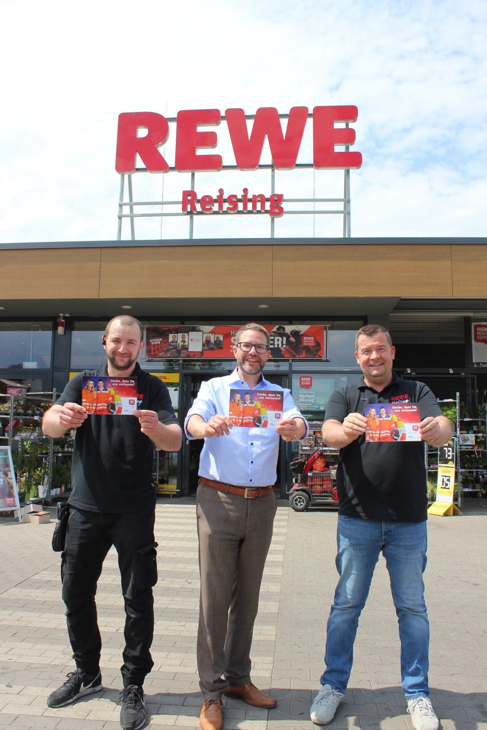Landrat Thorsten Stolz (Mitte) überbrachte dem Rewe-Lebensmittelmarkt Reising in Erlensee Werbematerial für die Aktion Rettungsgasse an der Kasse, hier mit Marktinhaber Michael Reising (rechts) und Marktleiter Milan Delic. 