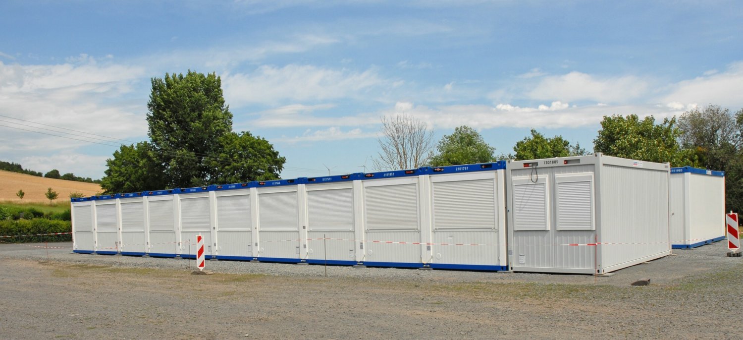 Seit Monaten geht es um Container als eine Unterkunft für Flüchtlinge, auf dem Platz (Parkplatz, Festplatz) vor dem Sportlerheim in Sannerz aufgestellt worden sind.