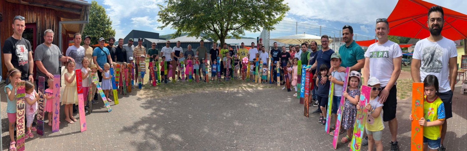 Viele bunte Holzlatten haben Väter mit ihren Kindern gestaltet. Sie werden künftig die Außenbegrenzung der Kinderburg Wiesenzauber verschönern. 
