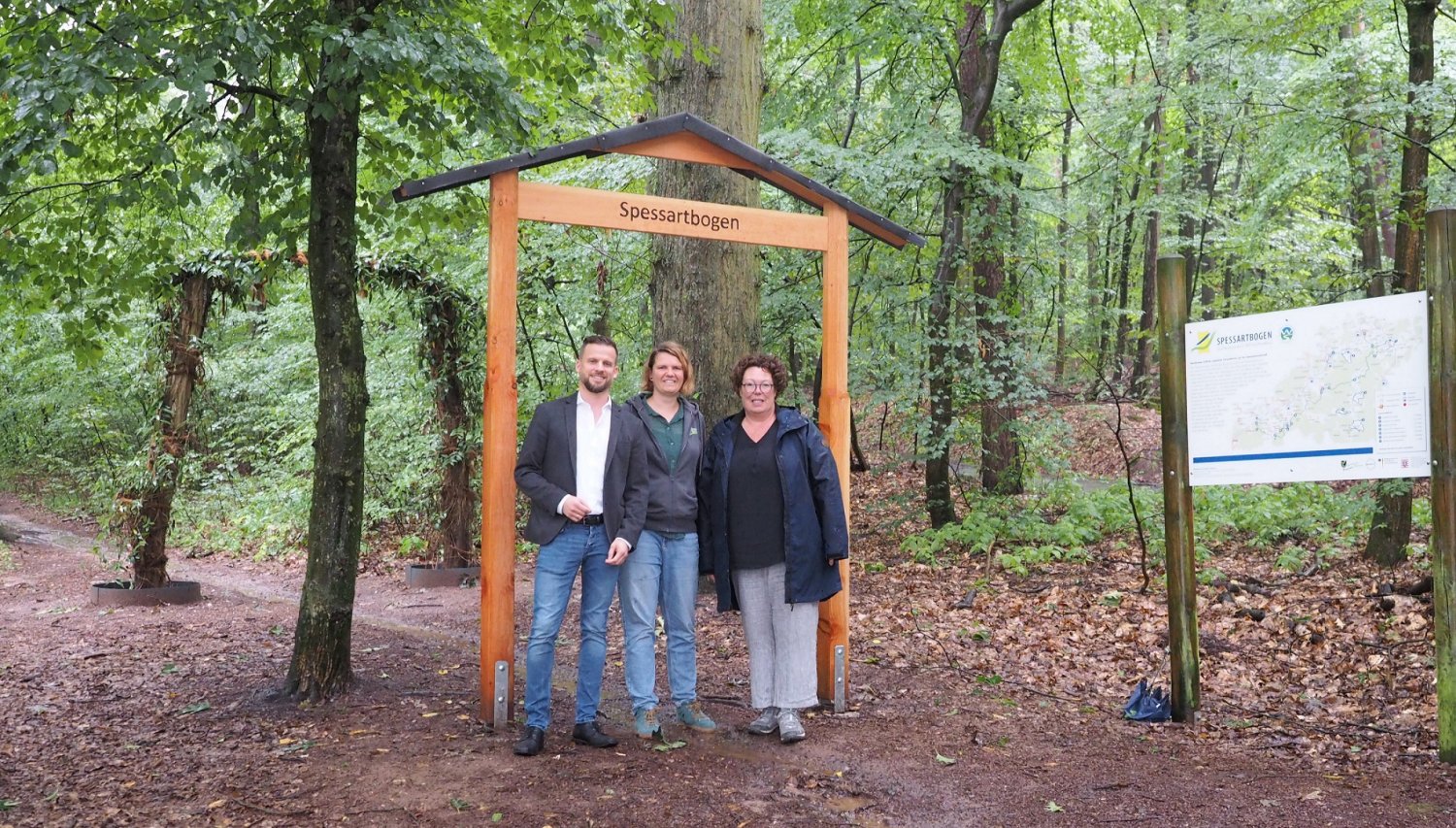 Erste Kreisbeigeordnete Susanne Simmler (rechts), Annika Ludwig, Geschäftsführerin des Zweckverbandes Naturpark Hessischer Spessart e.V, und Langenselbolds Bürgermeister Timo Greuel präsentieren den neuen Spessartbogen-Torbogen.
