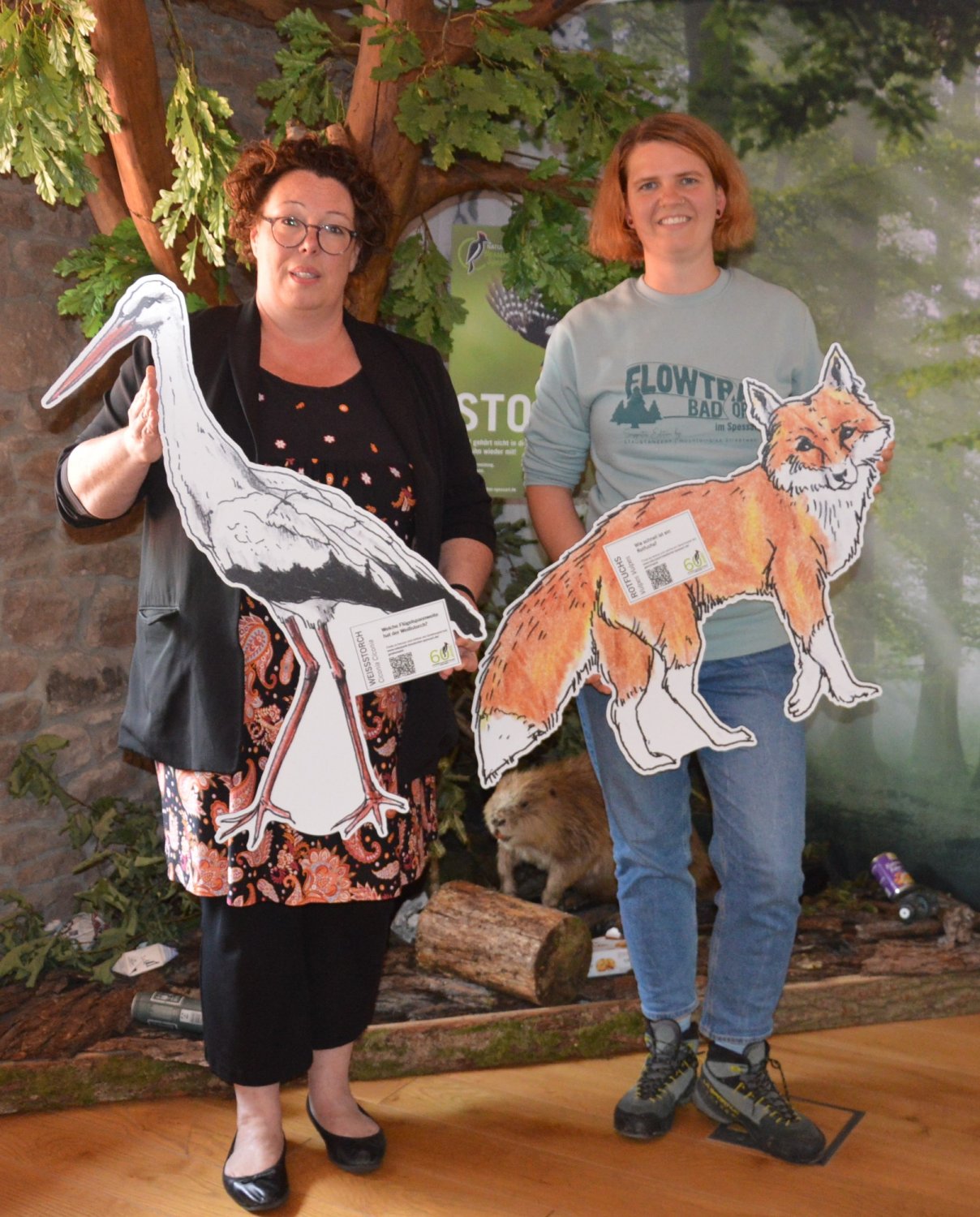 Erste Kreisbeigeordnete und Naturpark-Vorsitzende Susanne Simmler und Naturpark-Geschäftsführerin Annika Ludwig mit zwei von 15 im Wald versteckten Tiermodellen.