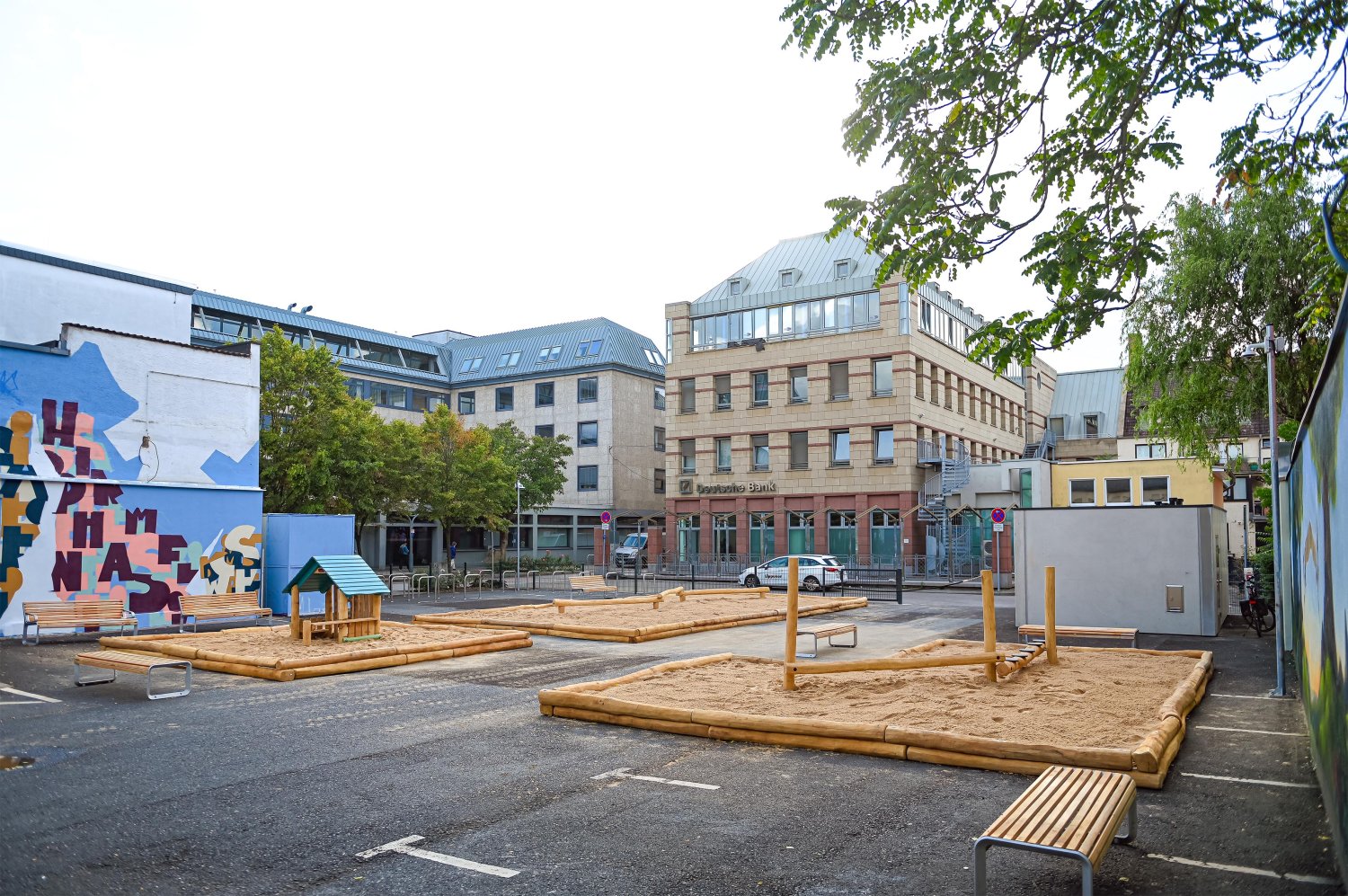 Statt die Fläche auf der Rückseite des Rathauses nur zum Abstellen von Pkw und Fahrrädern zu nutzen, hat sich die Stadt Hanau dazu entschieden, den Platz in einen neuen Aufenthaltsort mit Spielgeräten und Sitzflächen umzuwandeln.