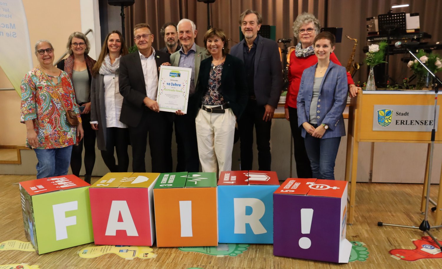 Fair Trade-Ehrenbotschafter Manfred Holz (5. von r.) überreichte die Urkunde zum Zehnjährigen Bestehen an Bürgermeister Stefan Erb (4.v.l.) und Renate Tonecker-Bös (4.v.r.).