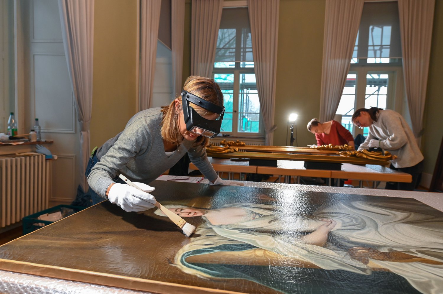 Die Gemälde im Schloss Philippsruhe in Hanau werden behutsam von (v. l.) Stefanie Gundermann, Elisabeth Ursprung und Claire Egenolf restauriert.