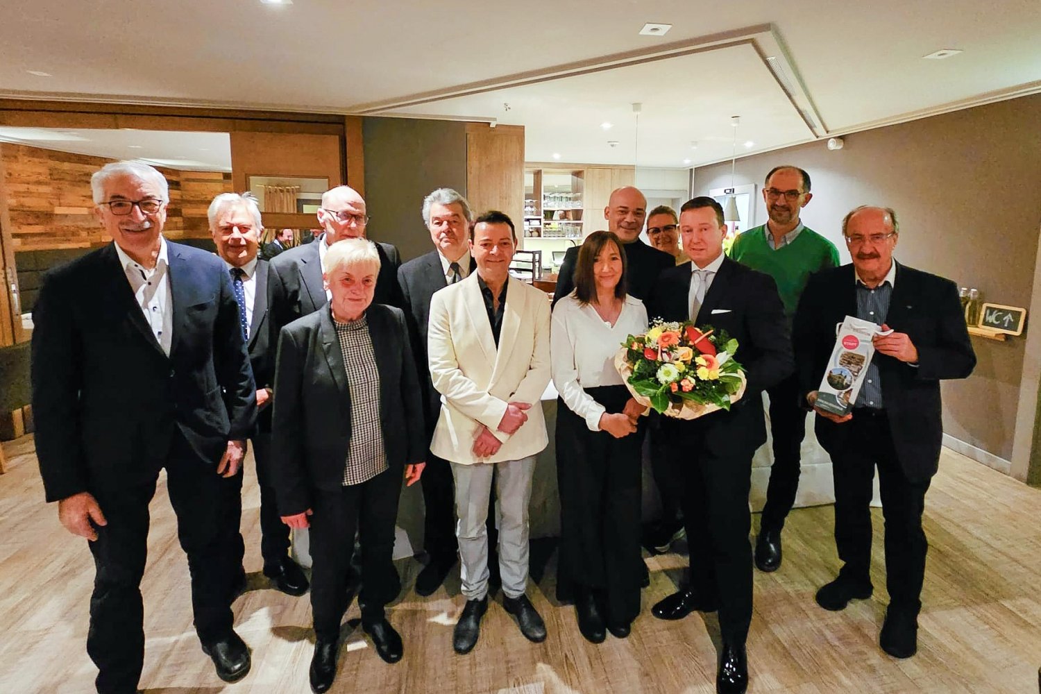 Giovanni Sistarelli (Sechster von links) und sein Team öffnen am Samstag das Stadthallenrestaurant Da Carlo. Bürgermeister Matthias Möller (Dritter von rechts) hat mit einer Delegation Geschenke vorbeigebracht.