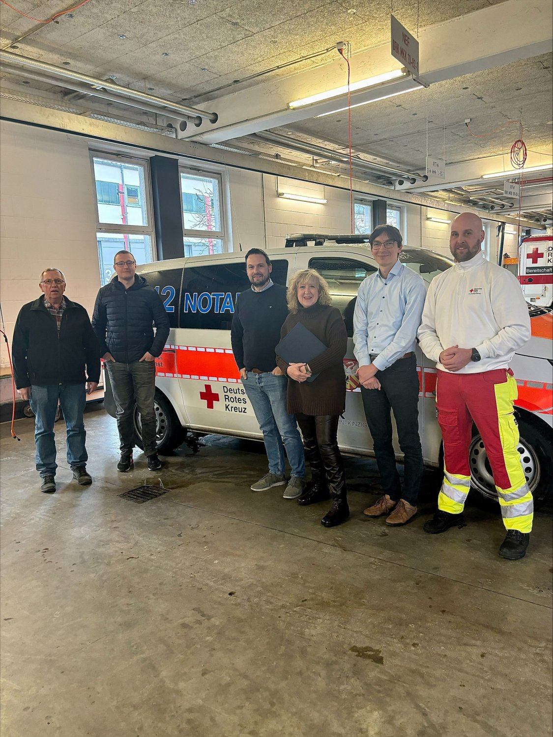 V.l.n.r.: Eugen Metzler, Jonas Zinke, Karsten de Man (alle DRK), Dr. Birgit Euteneuer (dqs), Fabian Gastine und Andy Hentschel (beide DRK) bei einem Rundgang durch die Fahrzeughalle des DRK-Kreisverbandes Gelnhausen-Schlüchtern.