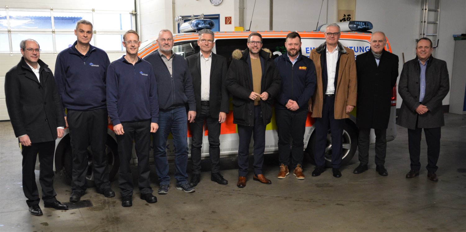 Auf dem Foto sind die Verantwortlichen der beteiligten Organisationen in der Fahrzeughalle des DRK Gelnhausen-Schlüchtern zu sehen.