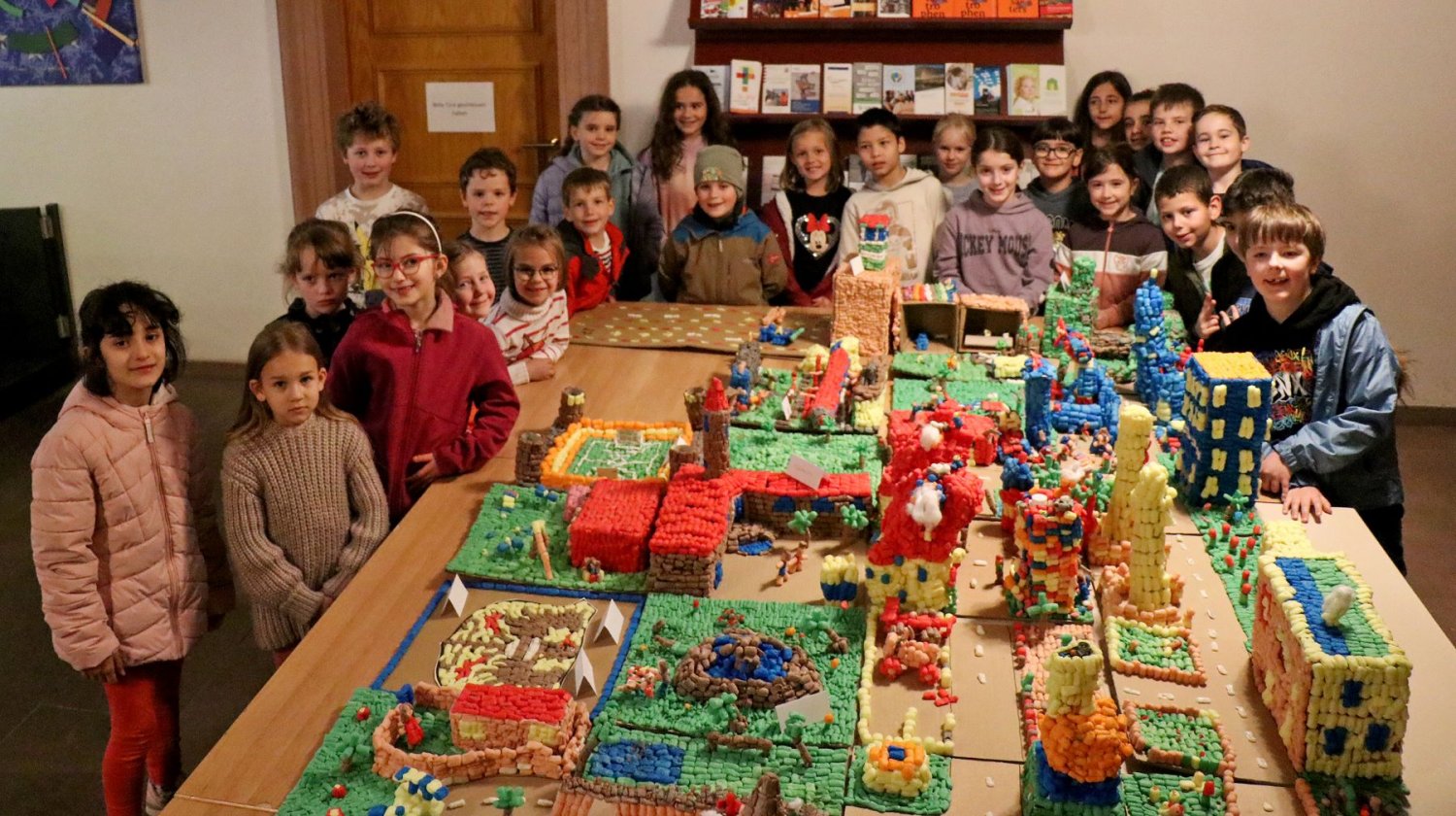 Die kleinen Baumeisterinnen und Baumeister der Philipp-Reis-Schule freuen sich, ihr Kunstwerk im Rathausfoyer präsentieren zu können.