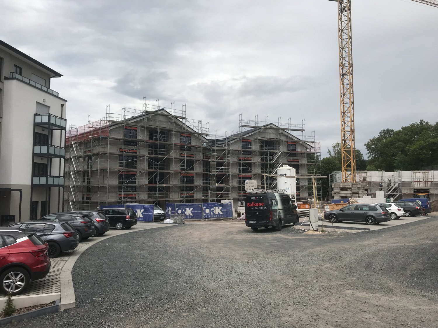 Die unterschiedlichen Entwicklungsstufen im ELMLAND 1: Während das linke Gebäude schon bewohnt wird, steht der 3. Komplex in der Mitte vor der Fertigstellung. Rechts der Rohbau des vierten Gebäudes.