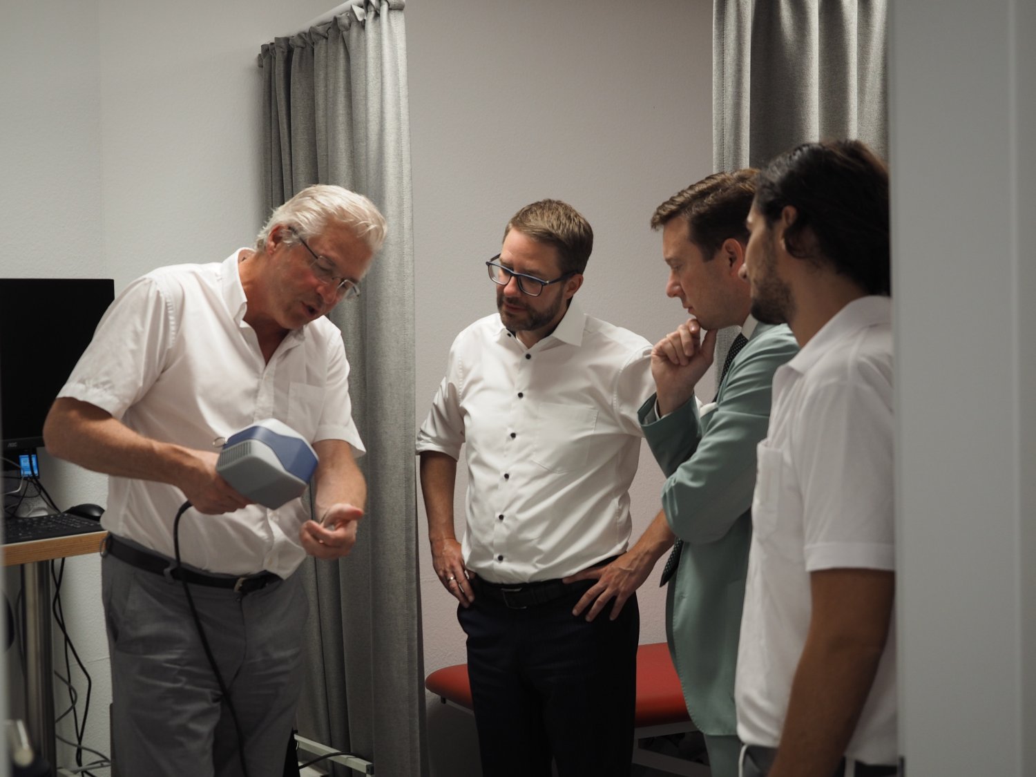 Professor Dr. Hans Michael Ockenfels (links) erläuterte Landrat Thorsten Stolz (Zweiter von links) und Schlüchterns Bürgermeister Matthias Möller (Zweiter von rechts) die Funktionsweise des von ihm mitentwickelten Lichtlasers.