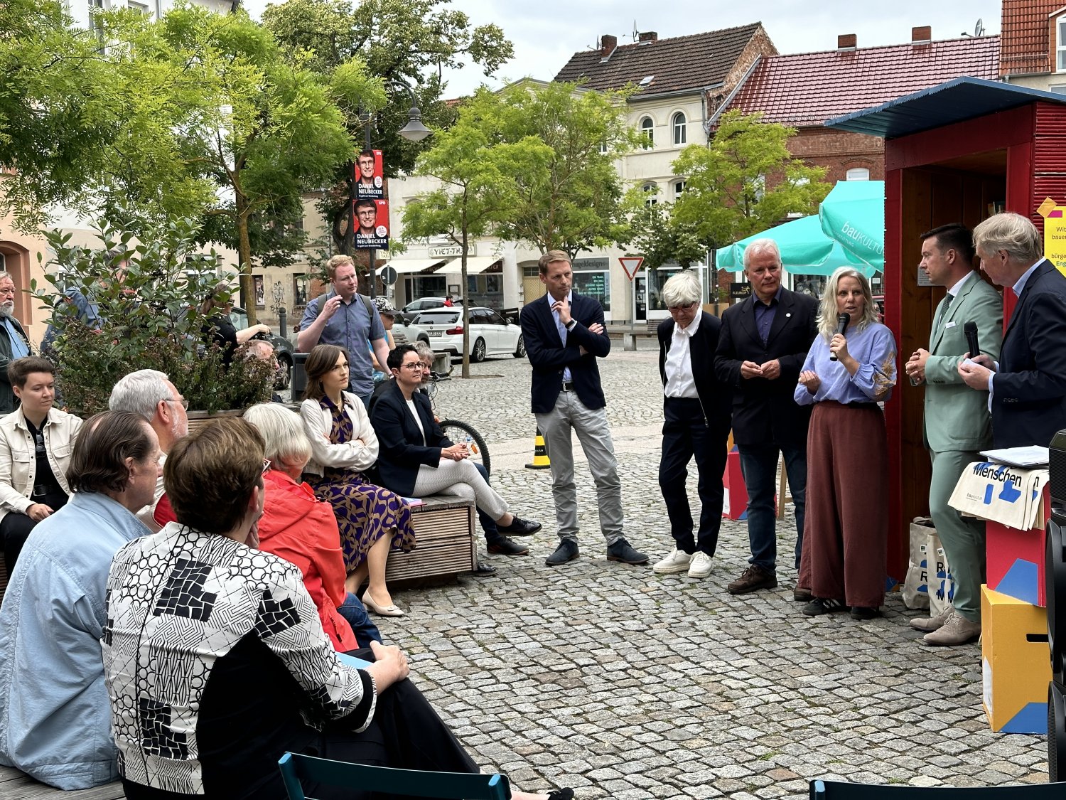 Auf dem zentralen Marktplatz von Wittenberge nahm Bürgermeister Matthias Möller (parteilos, hinten Zweiter von rechts) in Anwesenheit von Bundesbauministerin Klara Geywitz (SPD, vorne rechts) an einer Podiumsrunde teil.