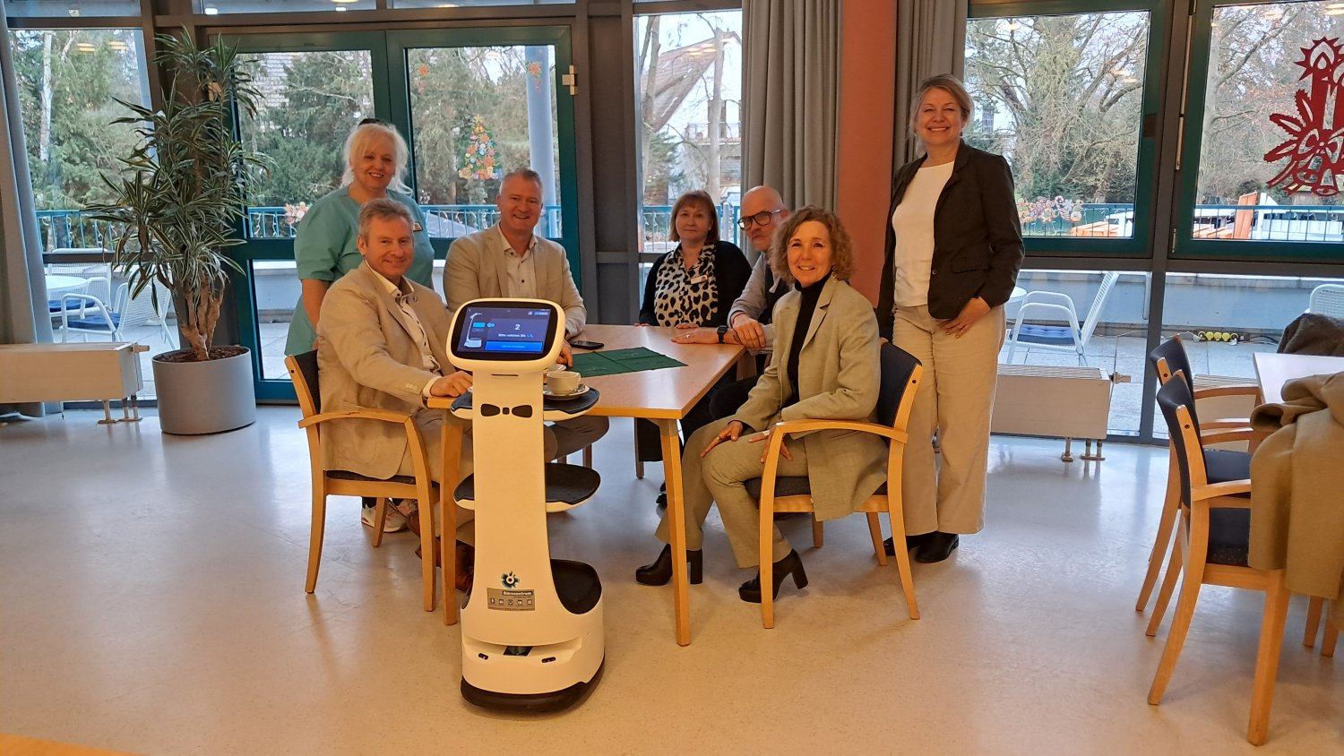 Rosemarie Sorber, Andreas Hofmann, Marco Maier, Milica Vlaoski, Daniel Funke, Iris Hurrlein und Yvonne Zednik (v.li.) lassen sich vom Serviceroboter bedienen.