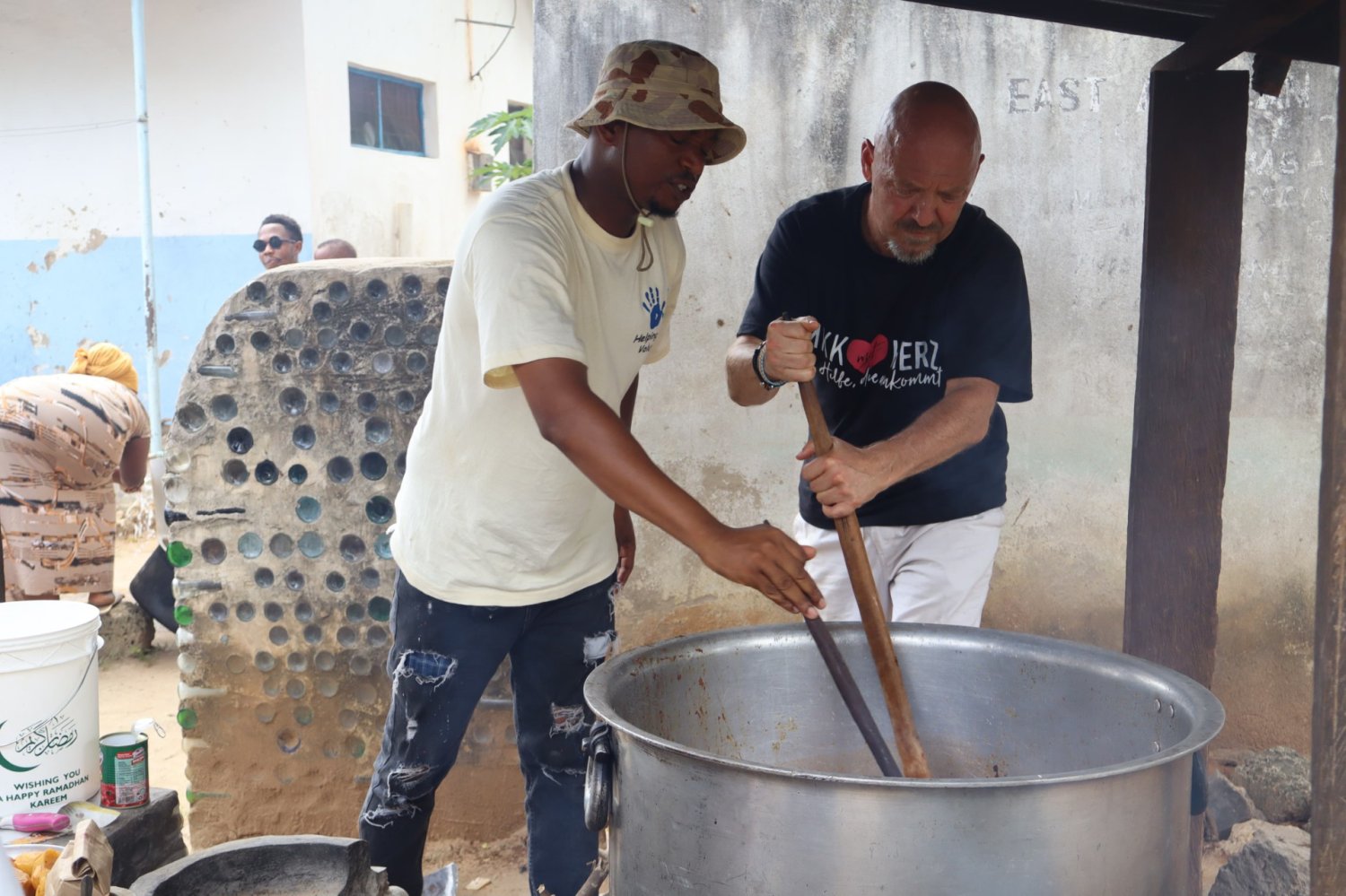 Gemeinsam mit Saidi, einem Helfer der Charity-Organisation „Helping Hands Volunteers“ kocht Davud Faghih-Zadeh (rechts) Mittagessen für Schülerinnen und Schüler der Milalani-Schule südlich von Mombasa.