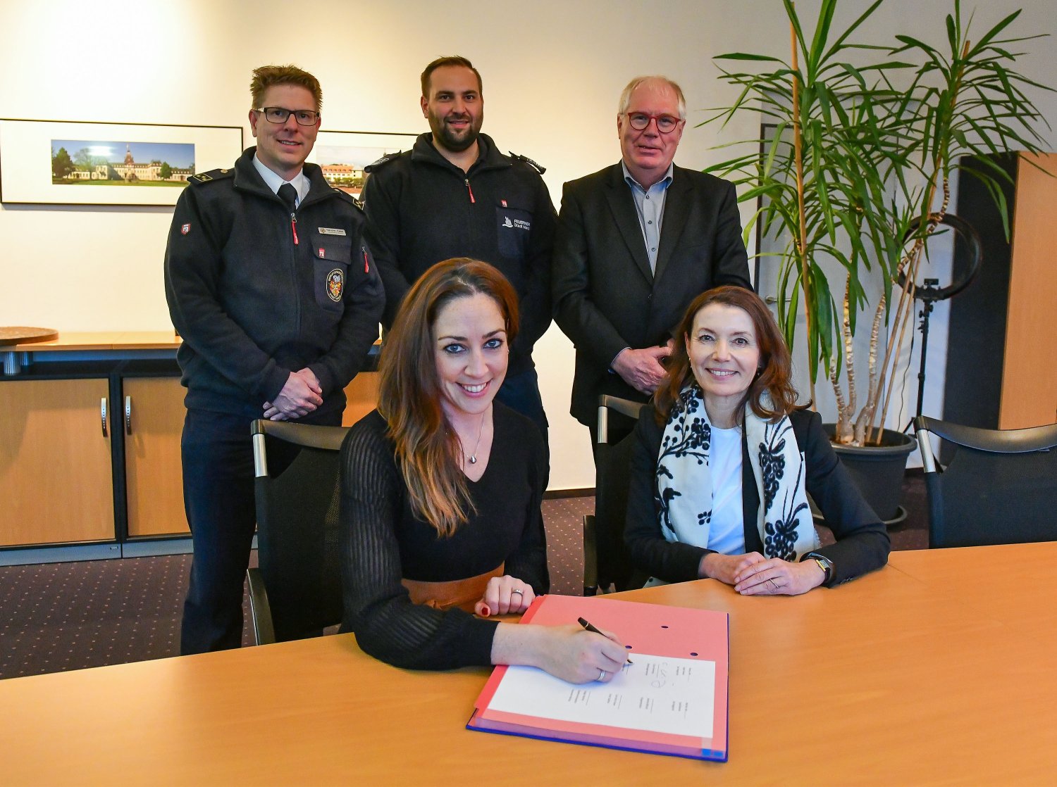 Bei der Unterschrift Hanaus Stadträtin und Feuerwehrdezernentin Isabelle Hemsley und Maintals Bürgermeister Monika Böttcher. Dahinter (v.li.) Hanaus Feuerwehrchef Hendrik Frese, Maintals Stadtbrandinspektor Holger Martiker und Karl-Heinz Kaiser.